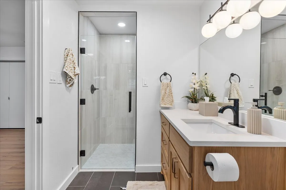 Wood-finish vanity with an integrated sink and matte black faucet
