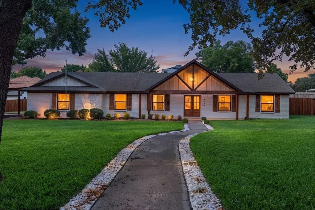 White brick exterior with dark trim and wood shutters