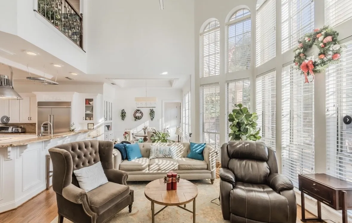 Living room featuring a towering ceiling and light hardwood / wood-style flooring