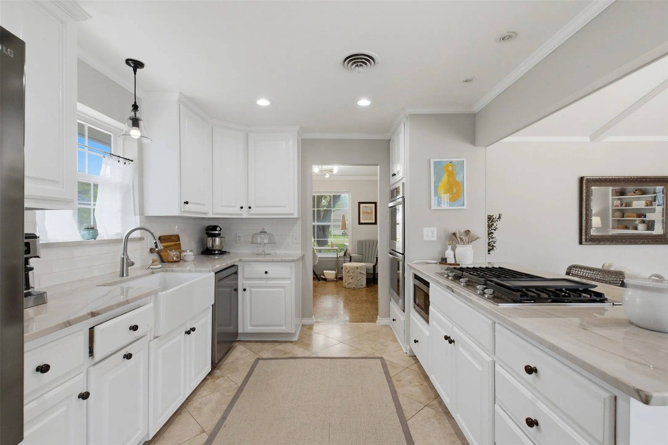 White cabinetry, recessed lighting, tile flooring, built-in double ovens, and a gas cooktop