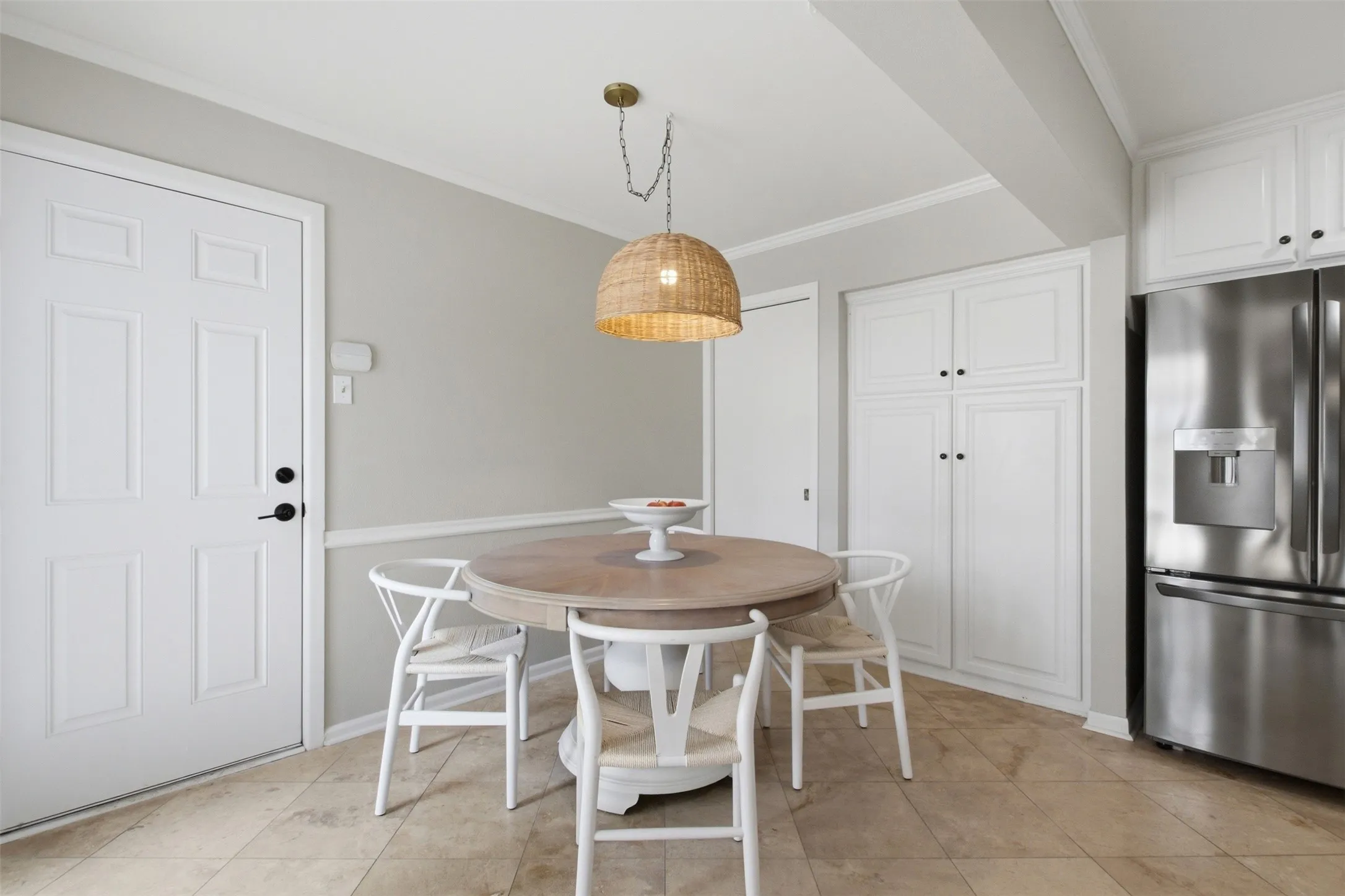 Built-in white cabinetry, stainless steel refrigerator, and recessed lighting