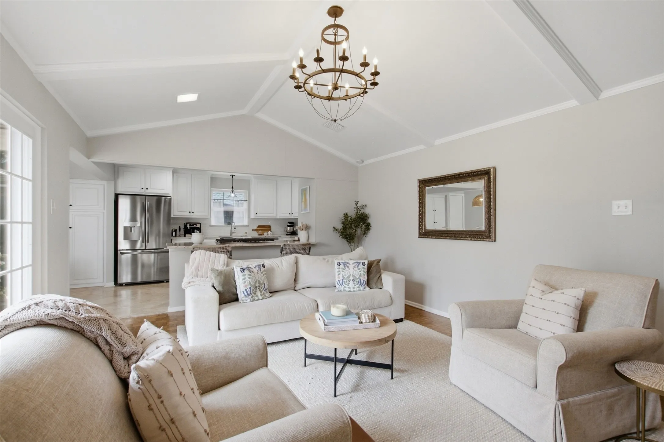 Vaulted ceiling with exposed beams, wood-finish flooring, recessed lighting, and kitchen with stainless steel appliances