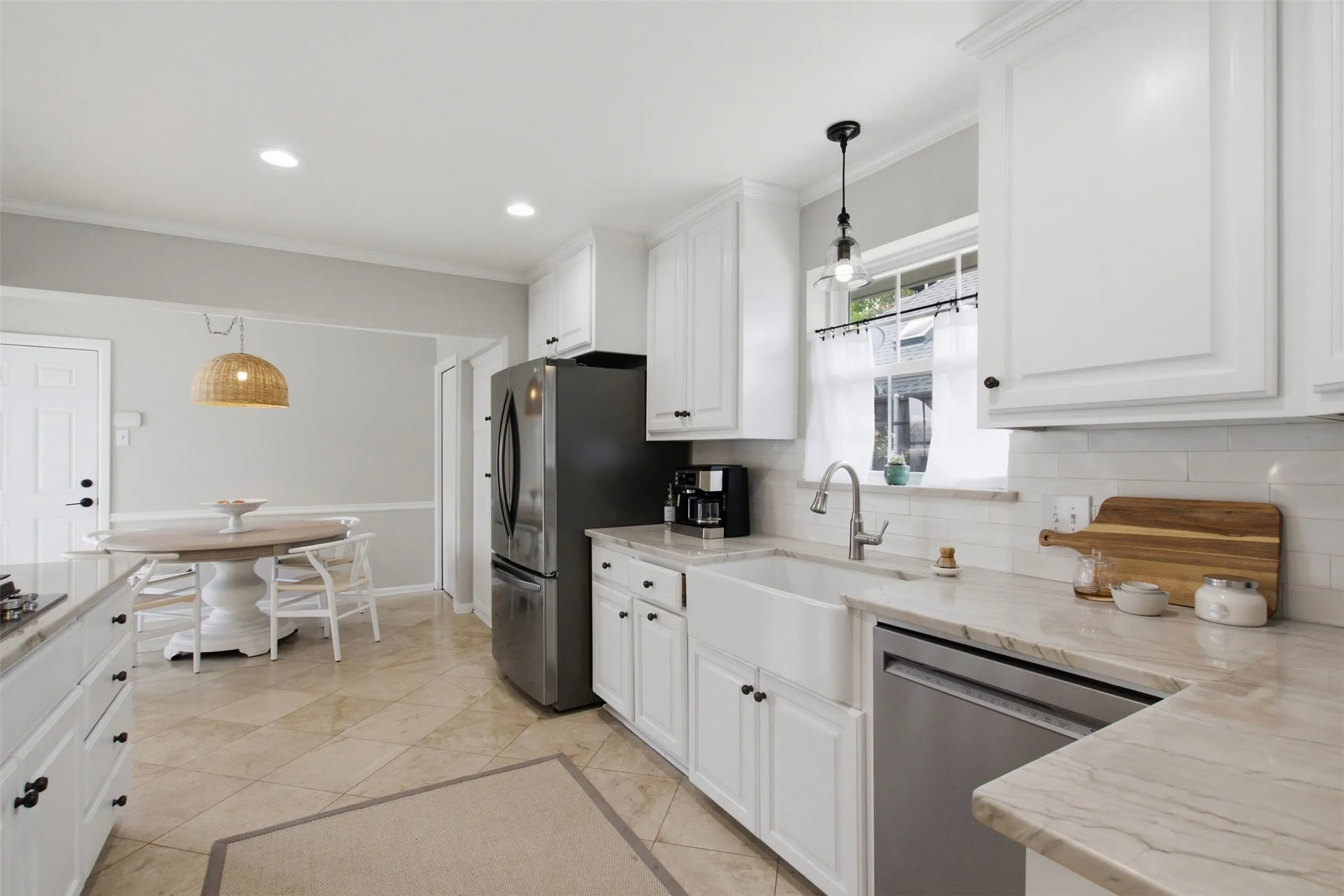 Kitchen featuring white cabinetry, stone-finish countertops, subway tile backsplash, and a farmhouse-style sink