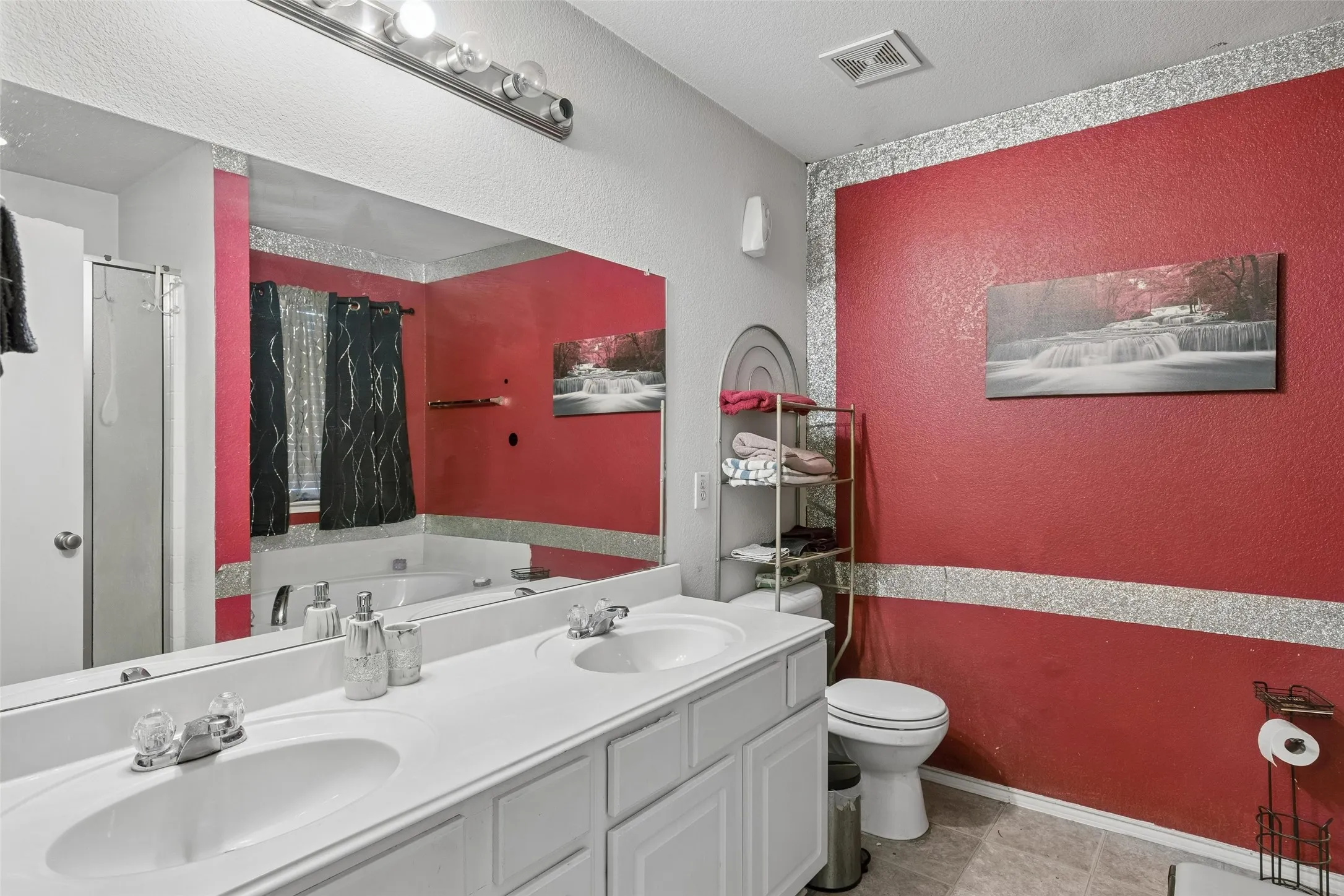 Dual vanity with integrated sinks, full-width mirror, recessed lighting, and a built-in bathtub