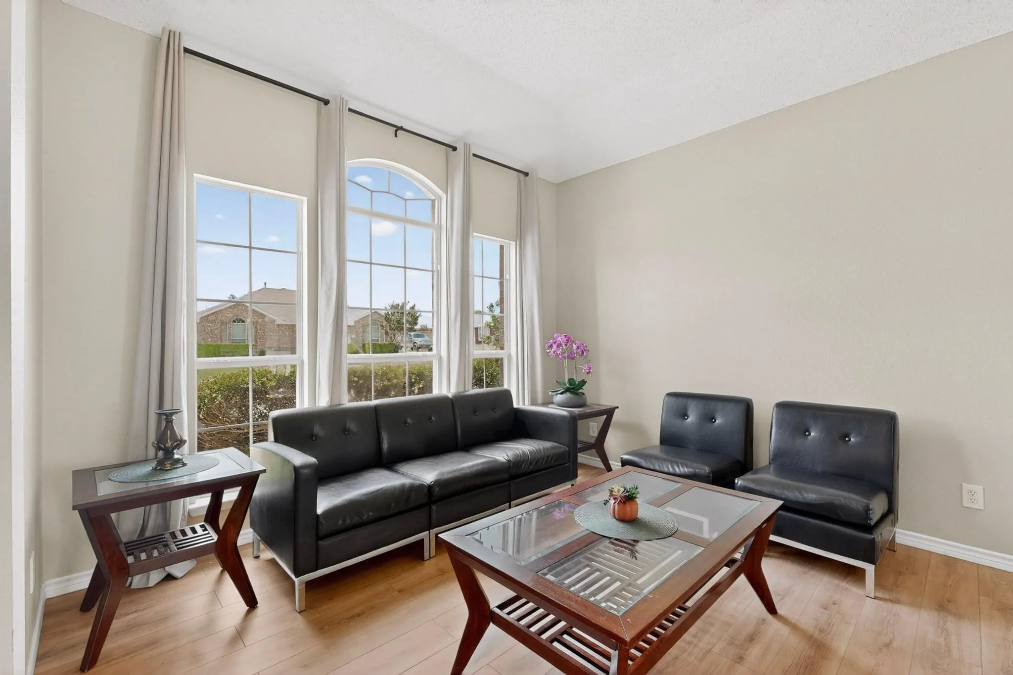 High ceilings, wood-finish flooring, and multiple large windows with architectural detailing