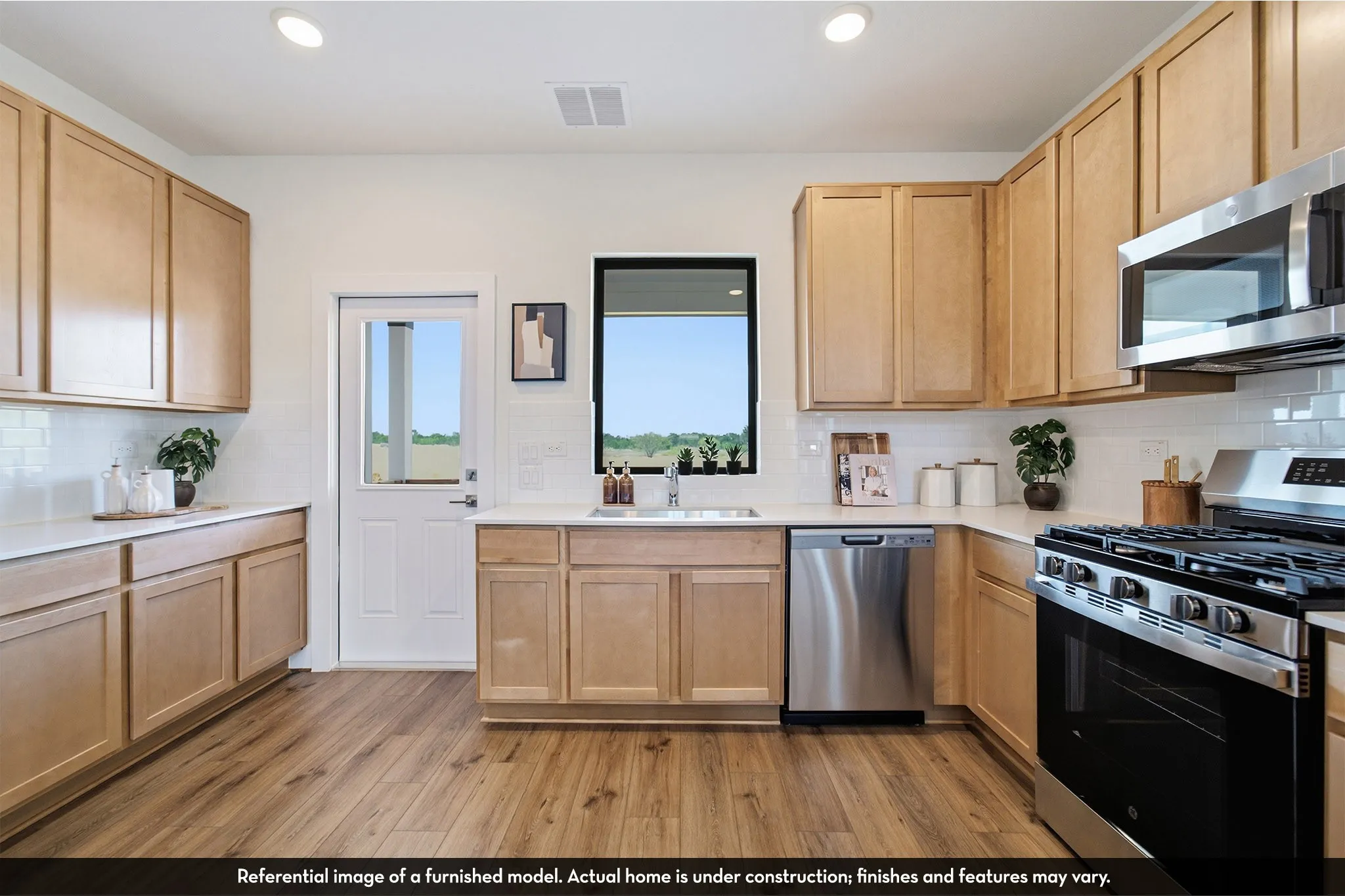 Kitchen featuring wood-finish flooring, light-toned cabinetry, stainless steel appliances, a subway tile backsplash, and recessed lighting