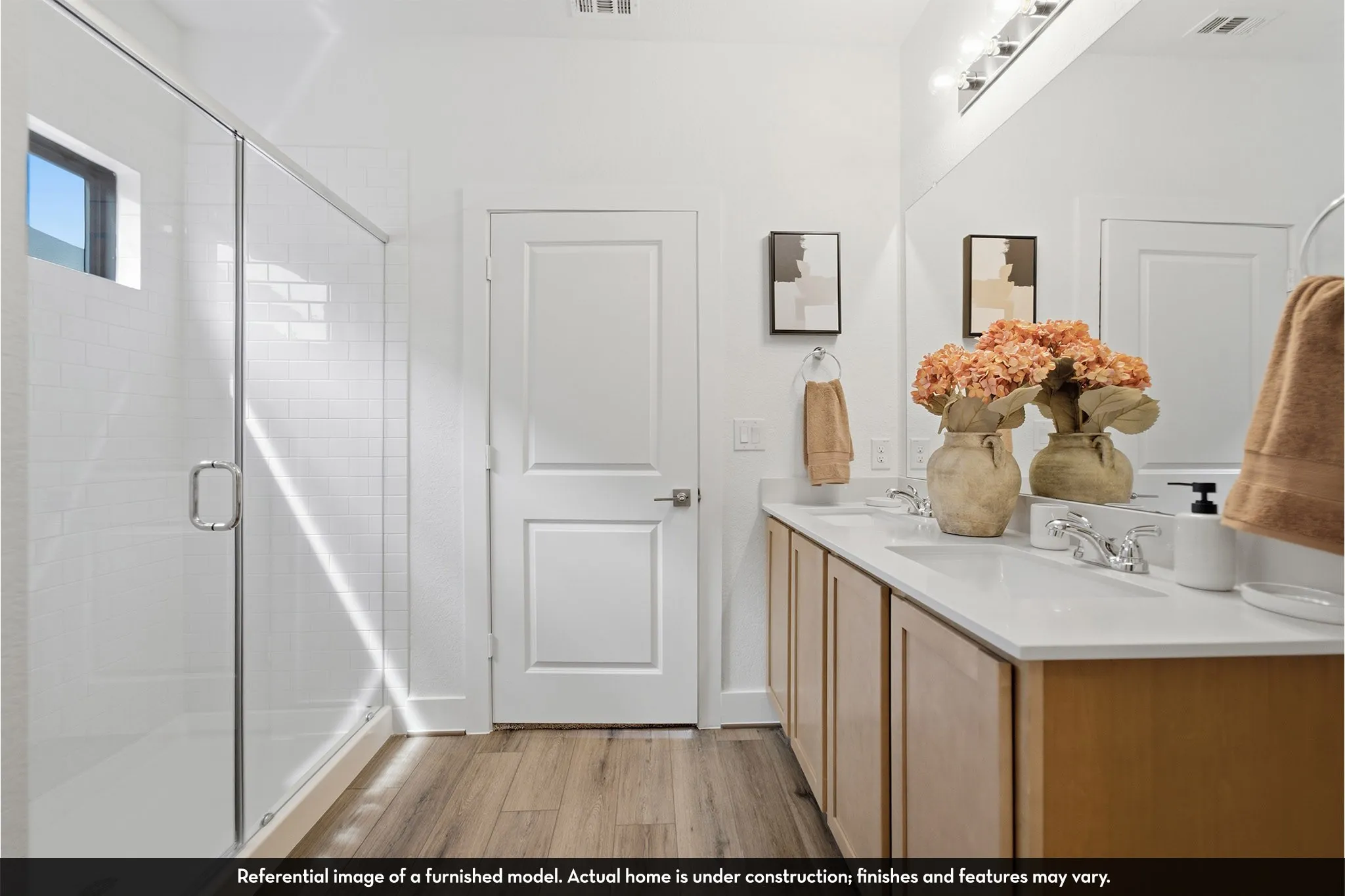 Dual vanity with integrated sinks, wood-finish cabinetry, chrome fixtures, and overhead lighting