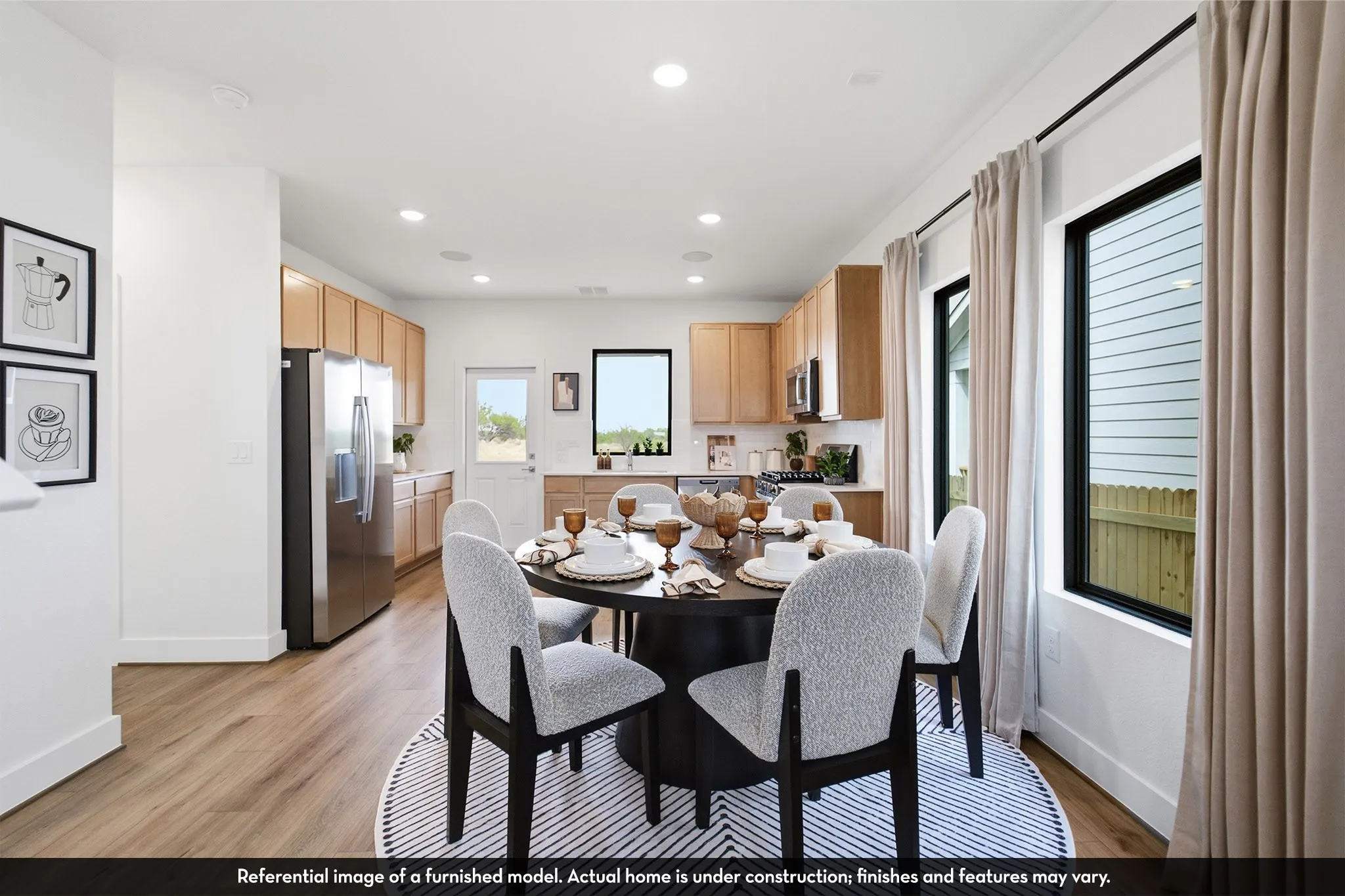 Wood-finish flooring, recessed lighting, and a modern kitchen with stainless steel appliances