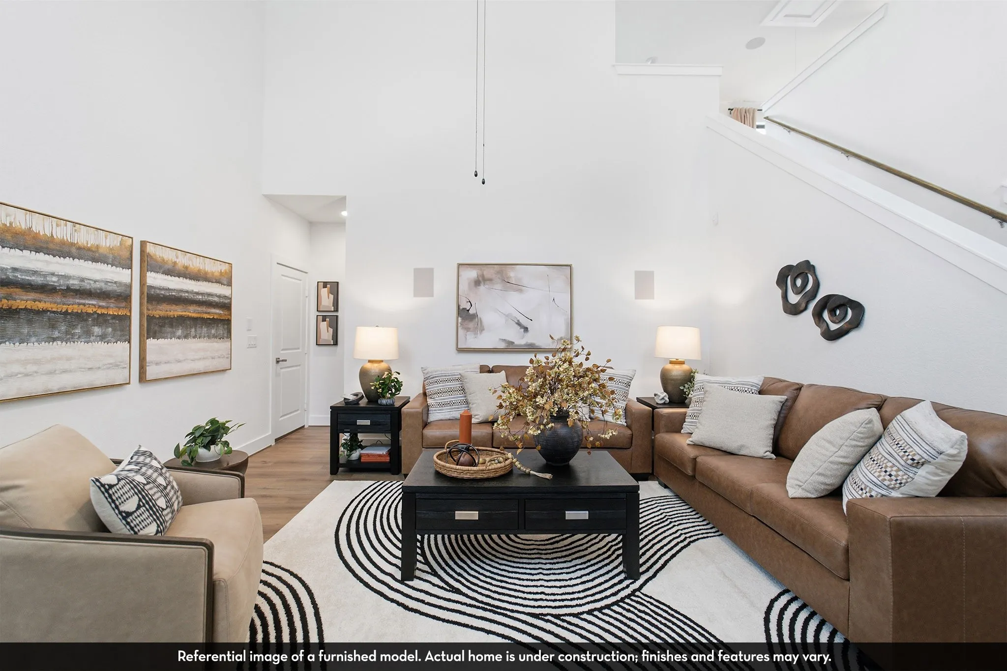 Vaulted ceilings, wood-finish flooring, built-in wall speakers, and a staircase with a wood handrail
