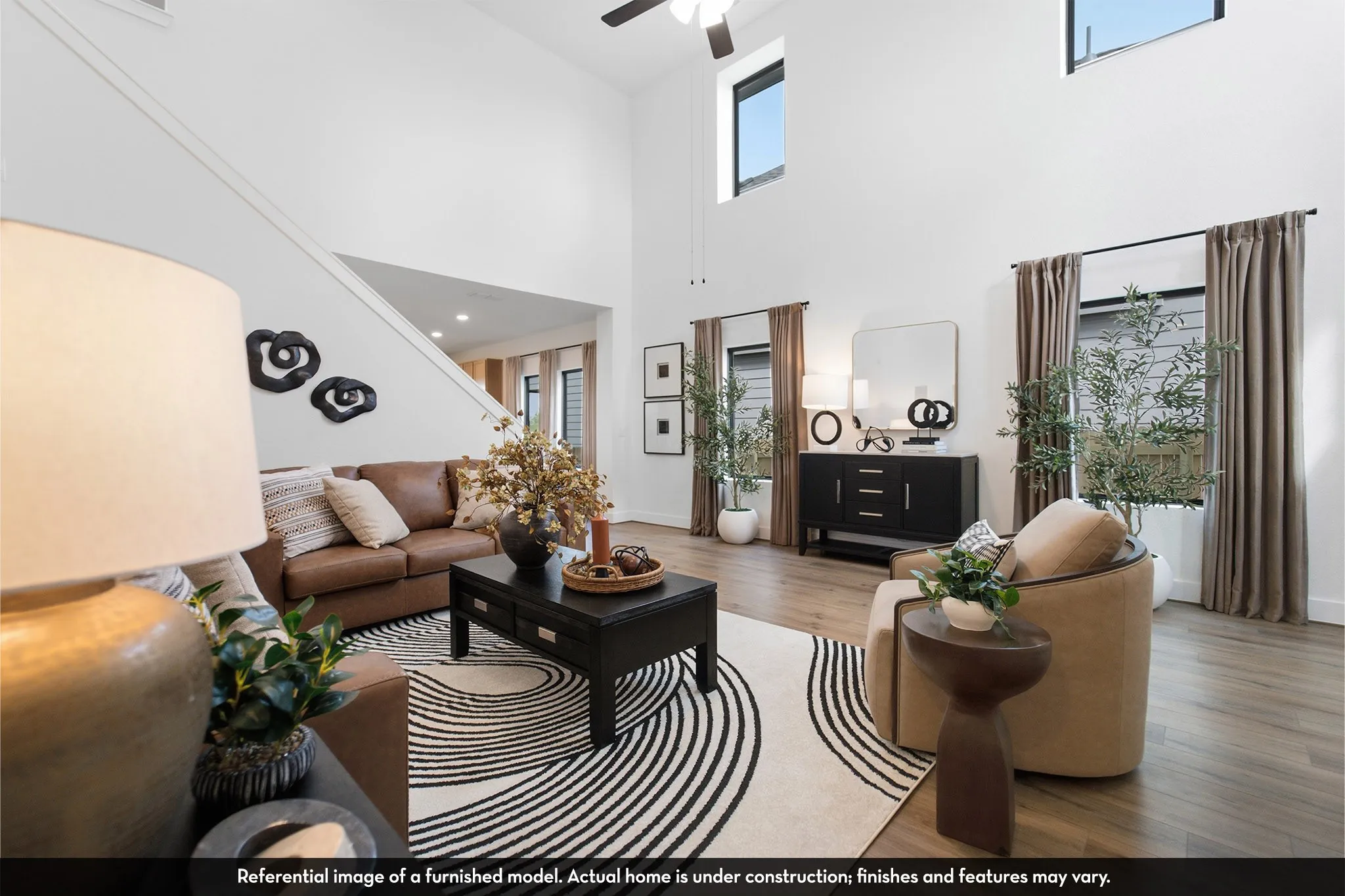 Expansive living area with high ceilings, upper windows, and wood-finish flooring