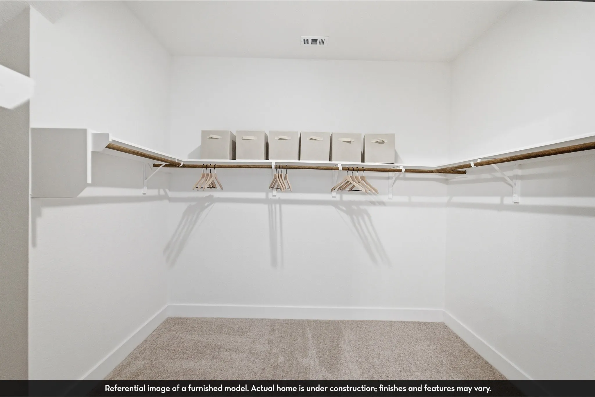 Carpeted walk-in closet with built-in shelving and hanging rods
