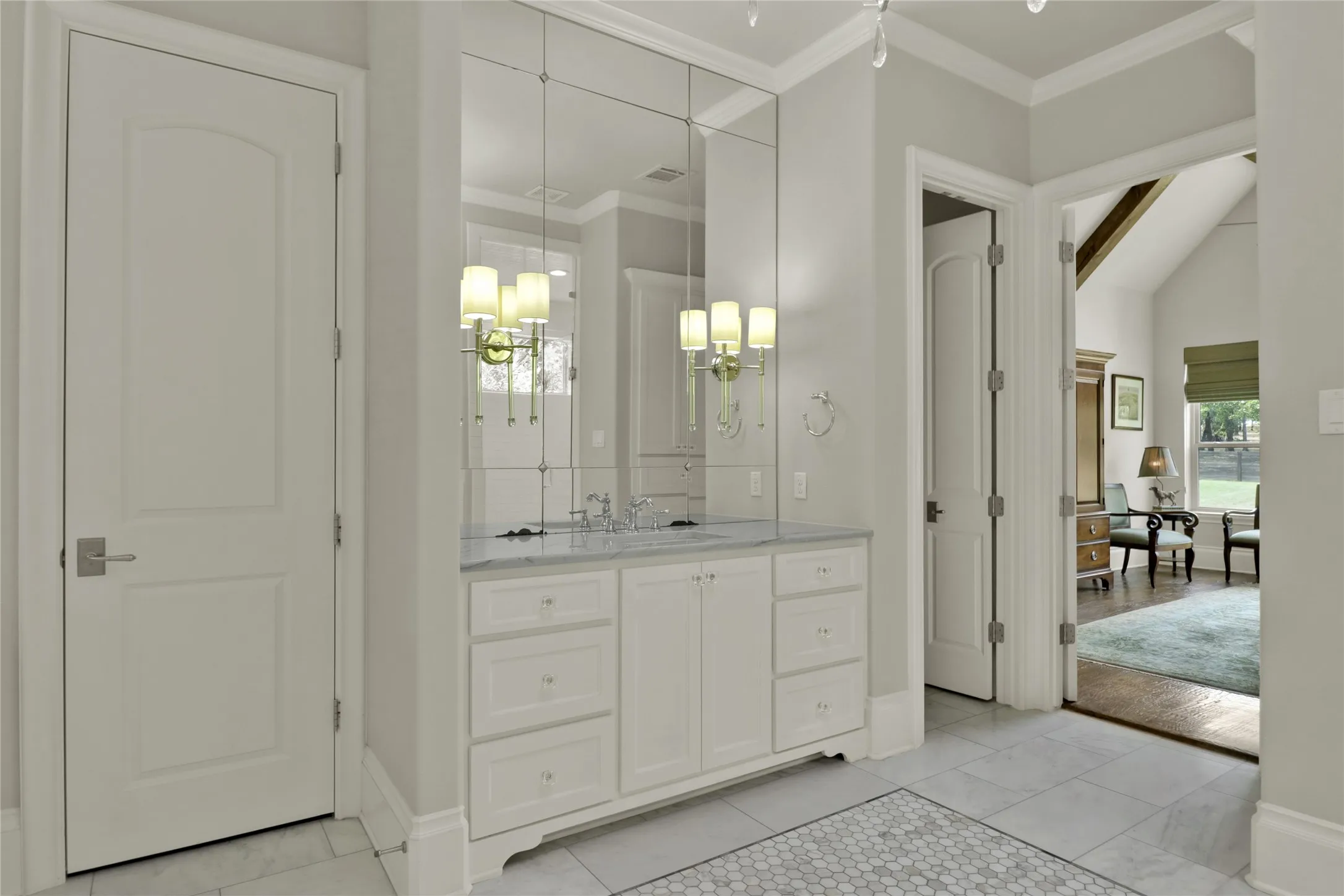 White vanity with a marble countertop, dual undermount sinks, and paneled mirror