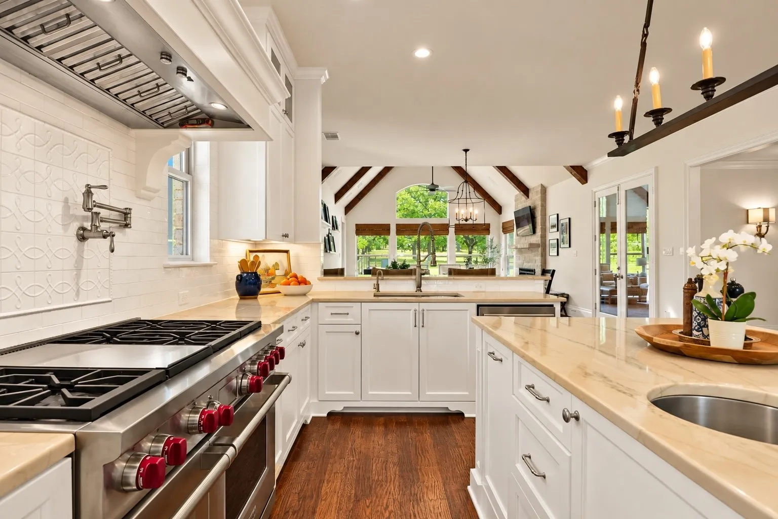 Gourmet kitchen featuring a stainless steel range, white cabinetry, light-toned countertops, and wood-finish flooring