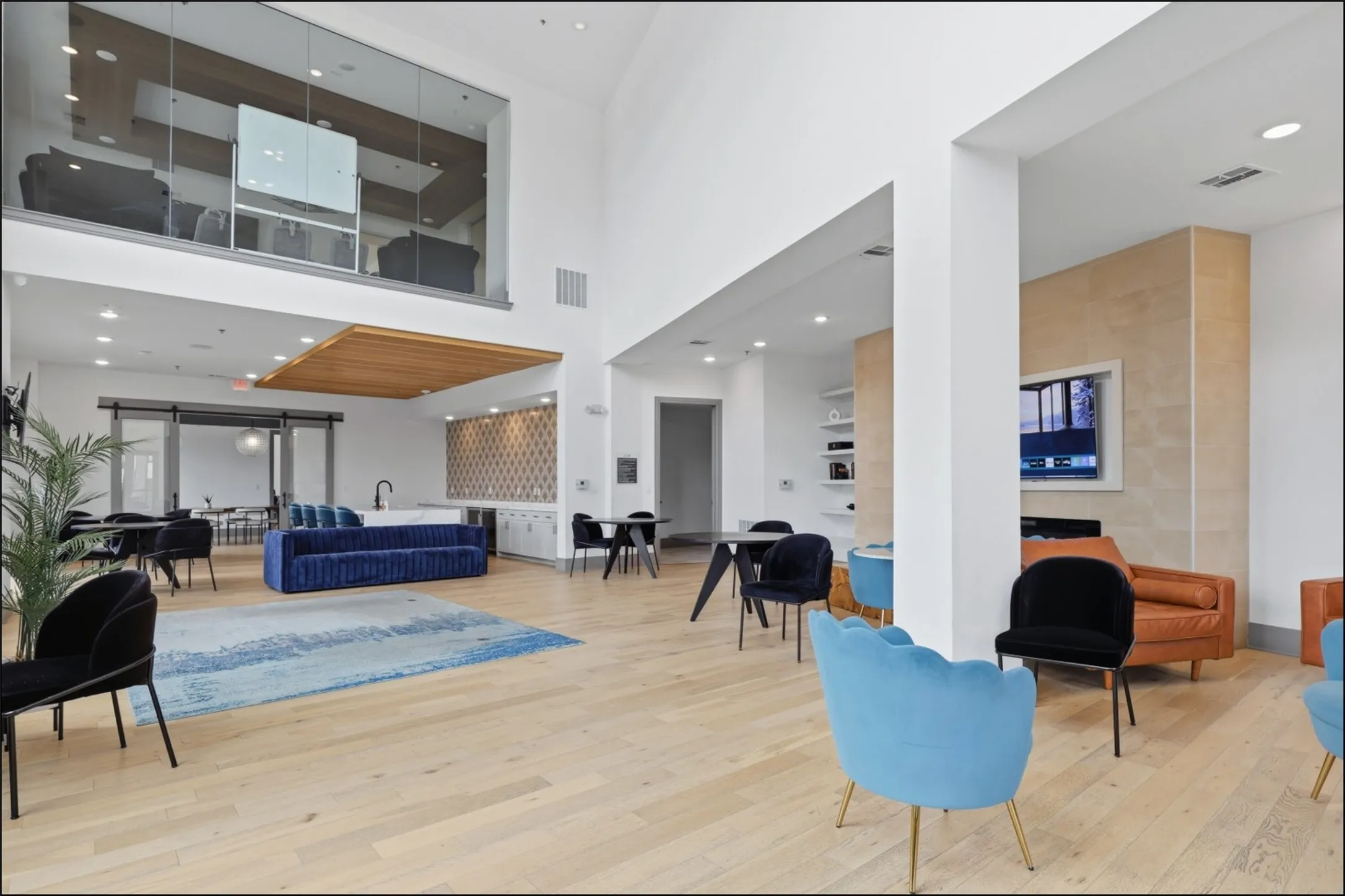 Two-story common area with soaring ceilings, recessed lighting, wood-finish flooring, and a built-in media center