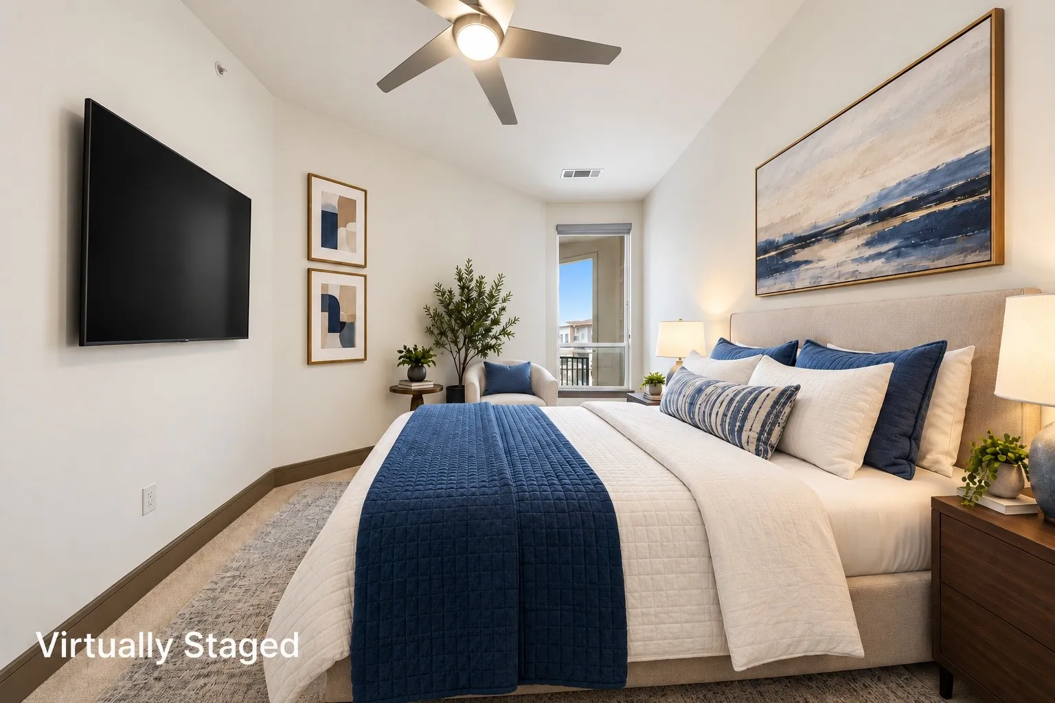 Sloped ceiling, ceiling fan with integrated lighting, wall-mounted television, and a window with a balcony