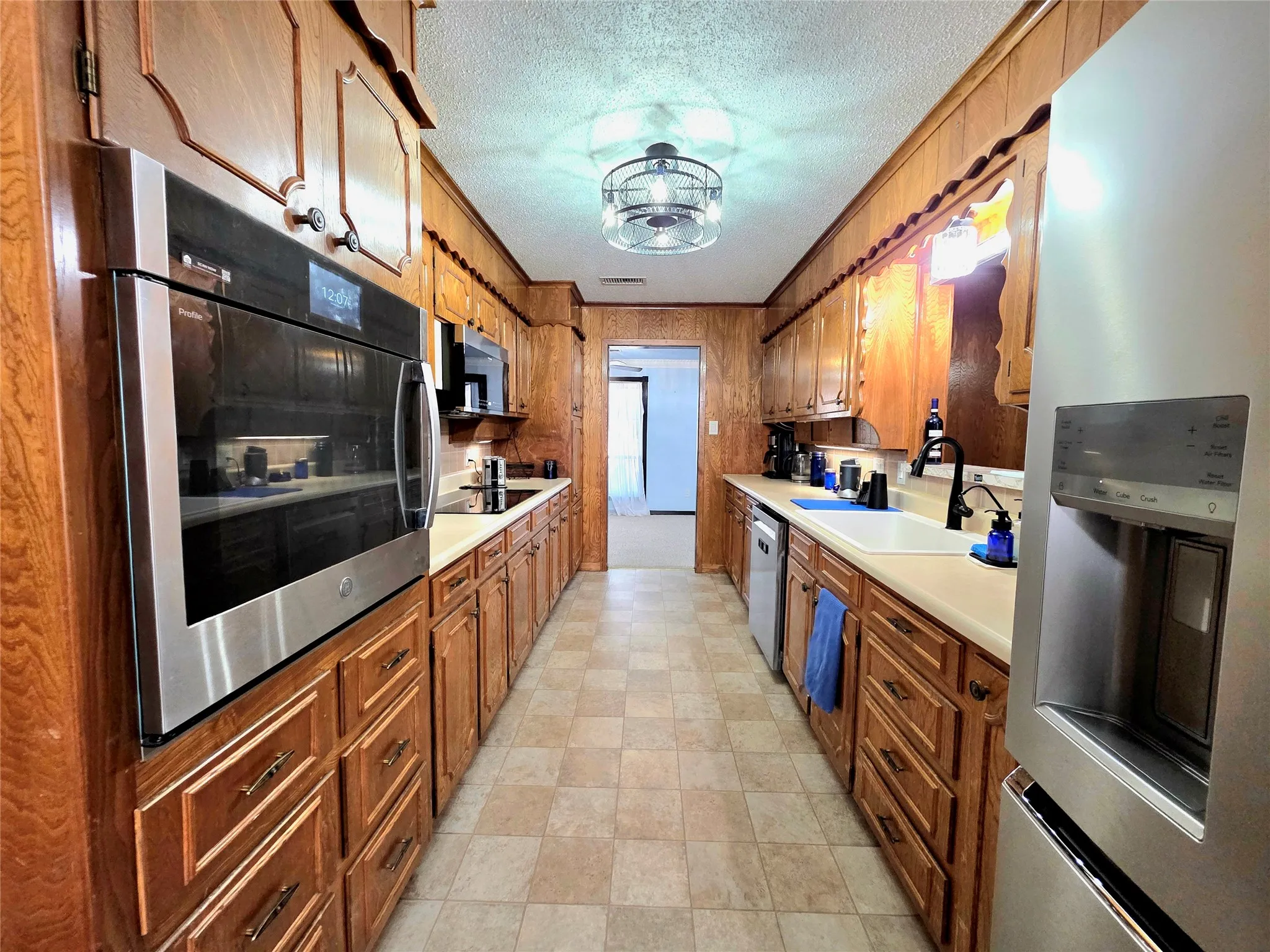 Well Appointed Galley Kitchen featuring upscale appliances and refrigerator.