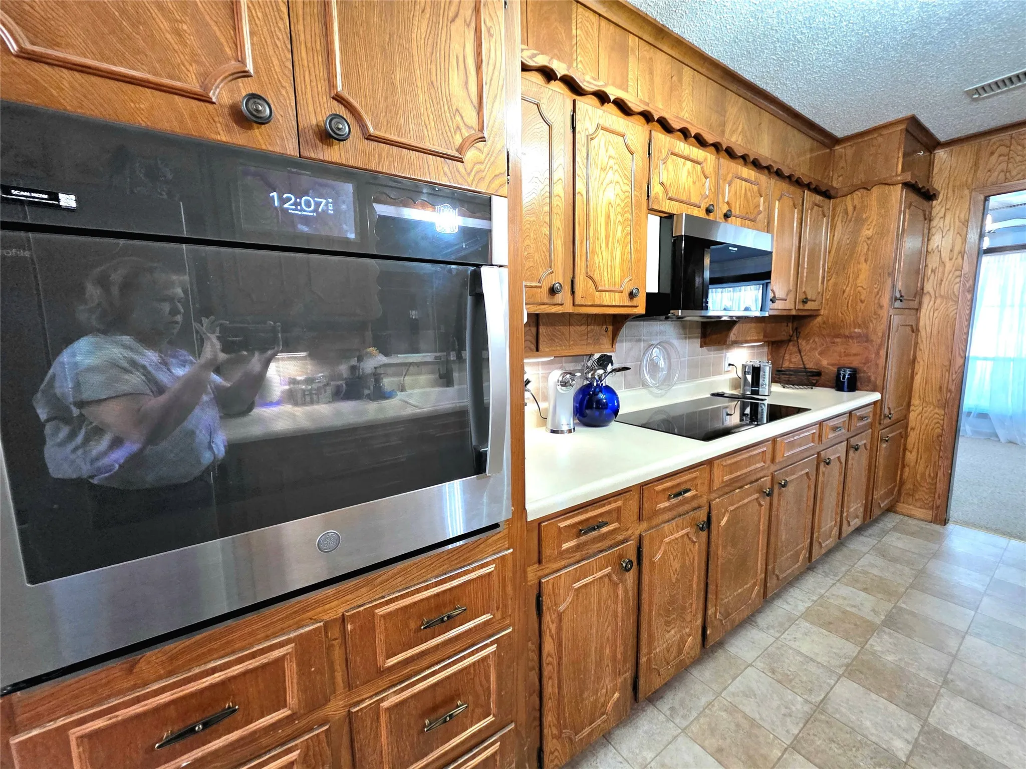 View two of large oven, smooth top cooktop and Microwave