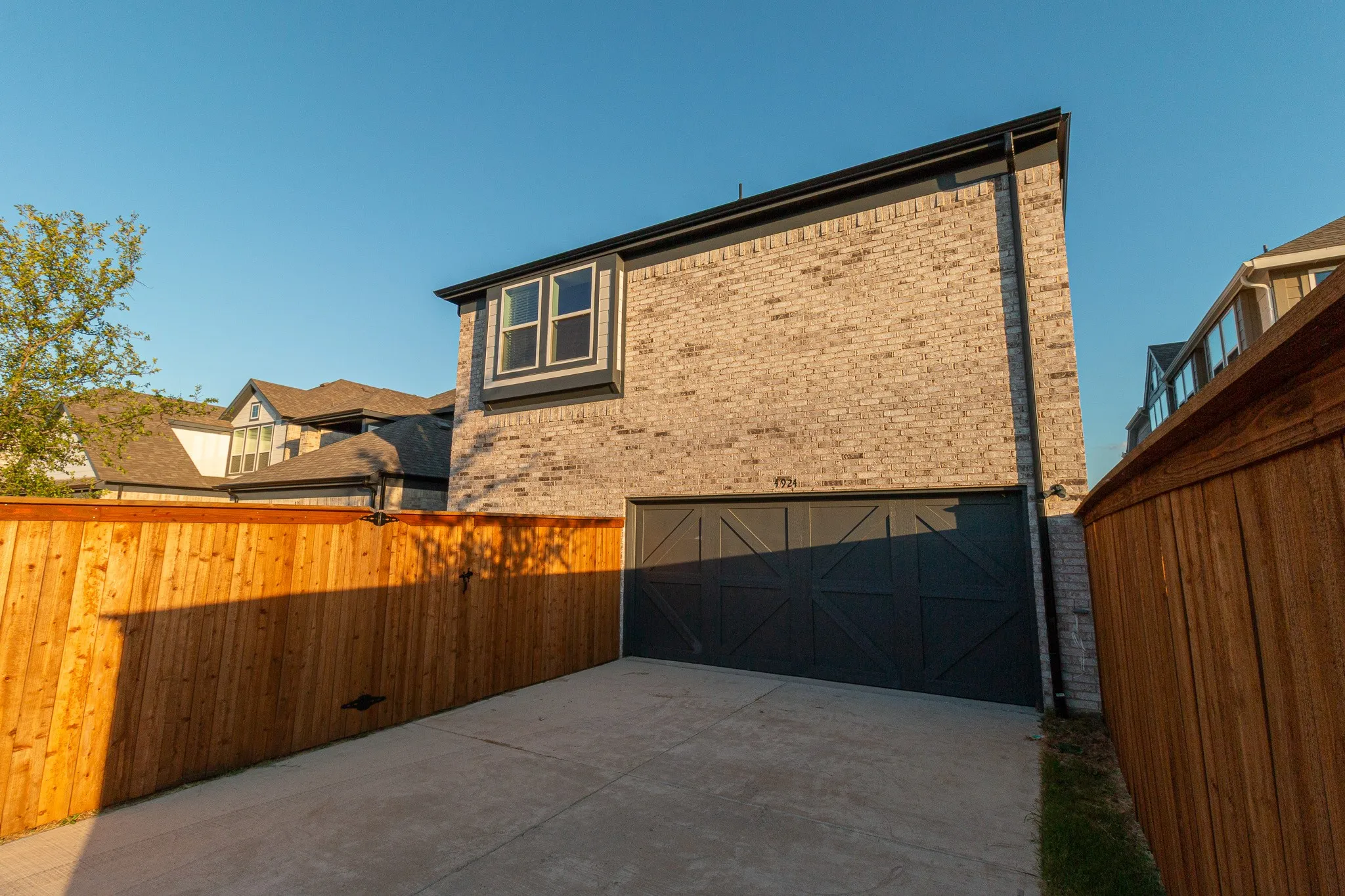 View of home's exterior featuring brick siding, concrete driveway, and an attached garage