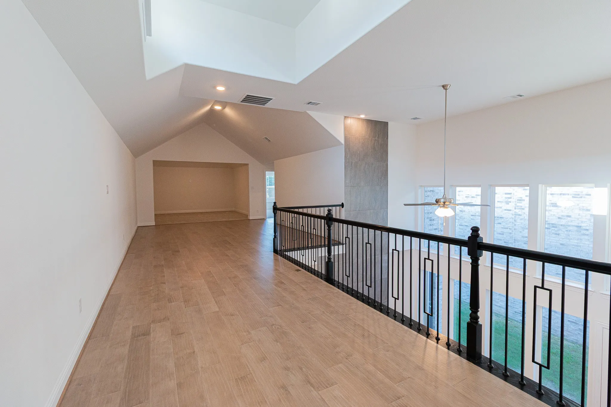 Hall featuring plenty of natural light, light wood-type flooring, recessed lighting, and vaulted ceiling