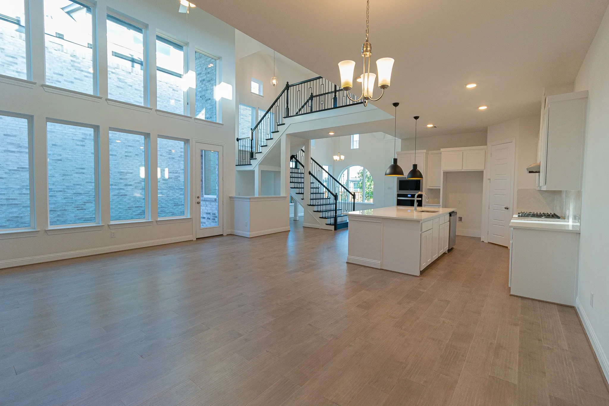 Kitchen with white cabinets, light countertops, a chandelier, decorative light fixtures, and stainless steel appliances