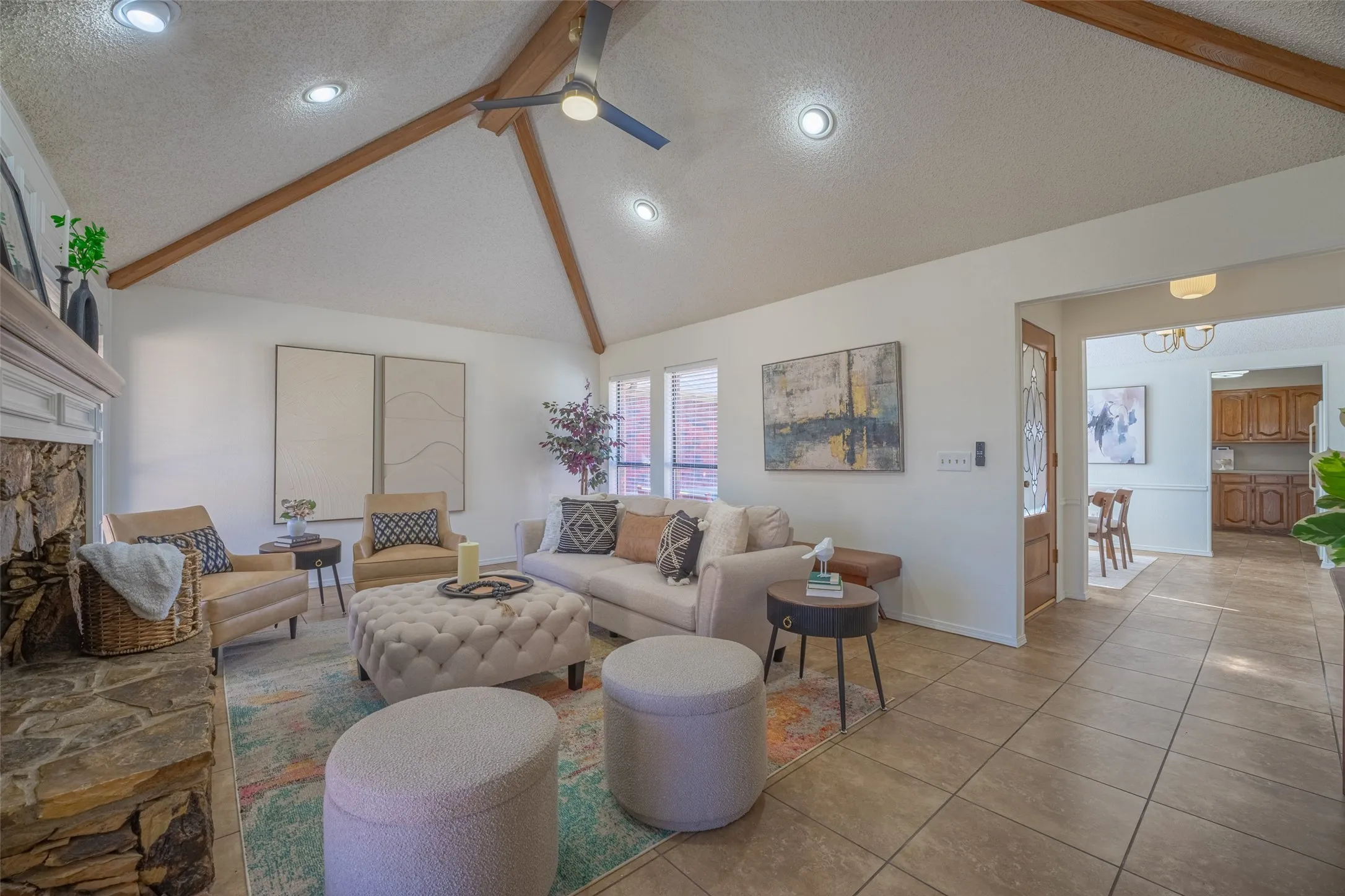 Vaulted ceiling with exposed wood beams, recessed lighting, and a ceiling fan