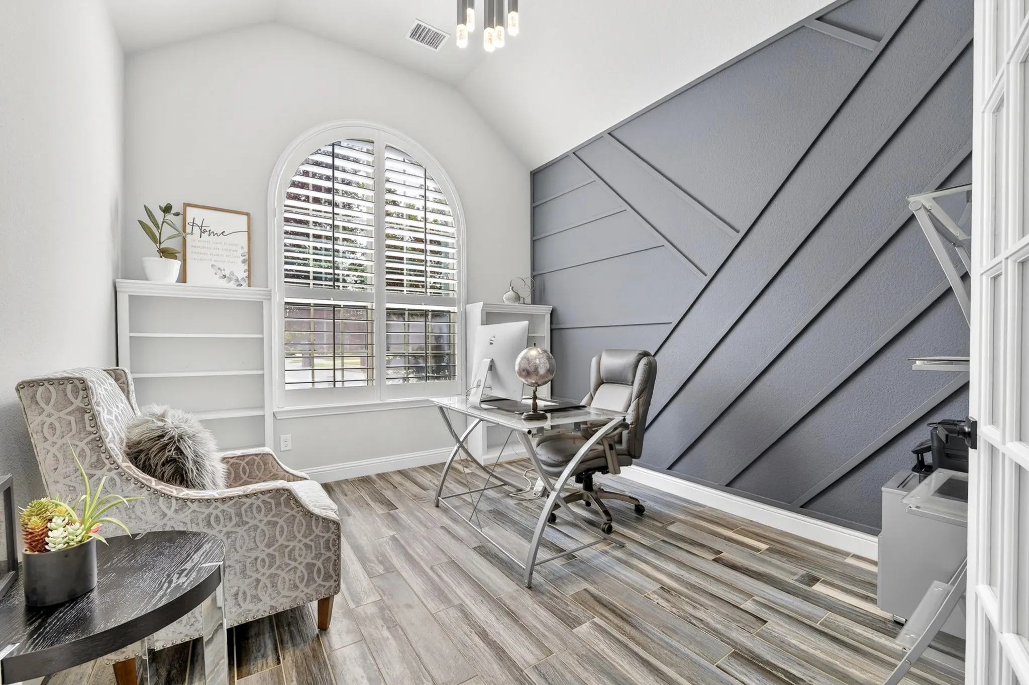 Vaulted ceiling with an arched window and plantation shutters