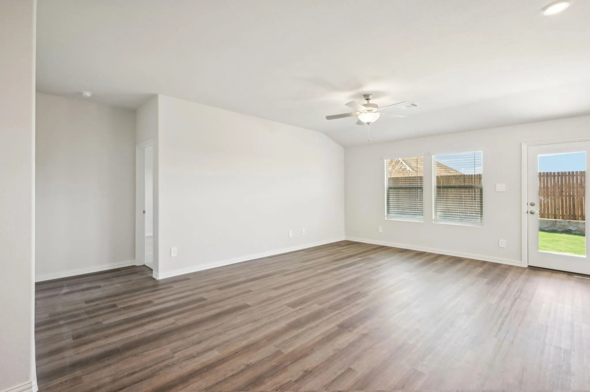 Spare room with ceiling fan, wood finished floors, and a wealth of natural light