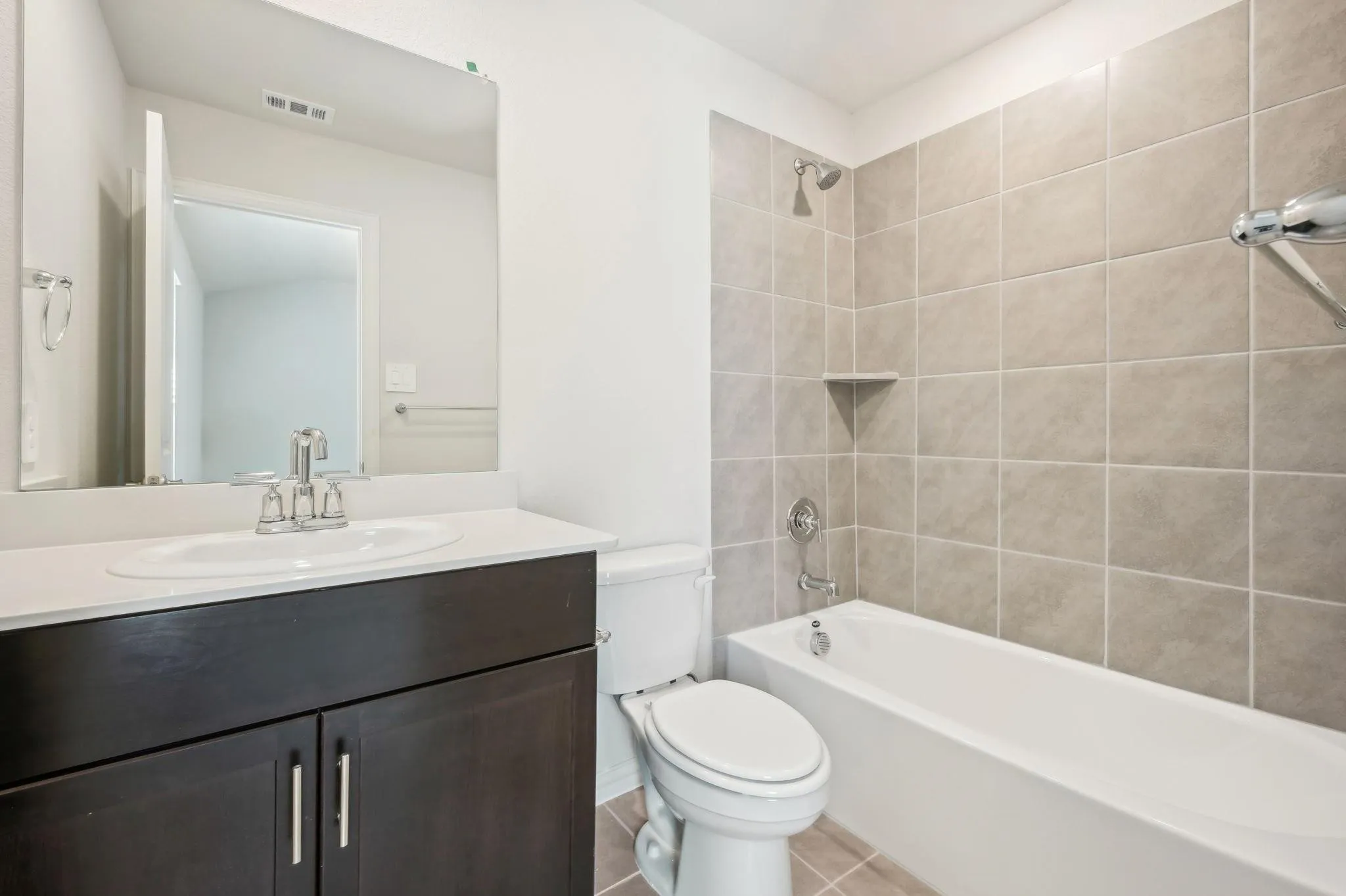 Bathroom with visible vents, tile patterned flooring, vanity, tub / shower combination, and toilet