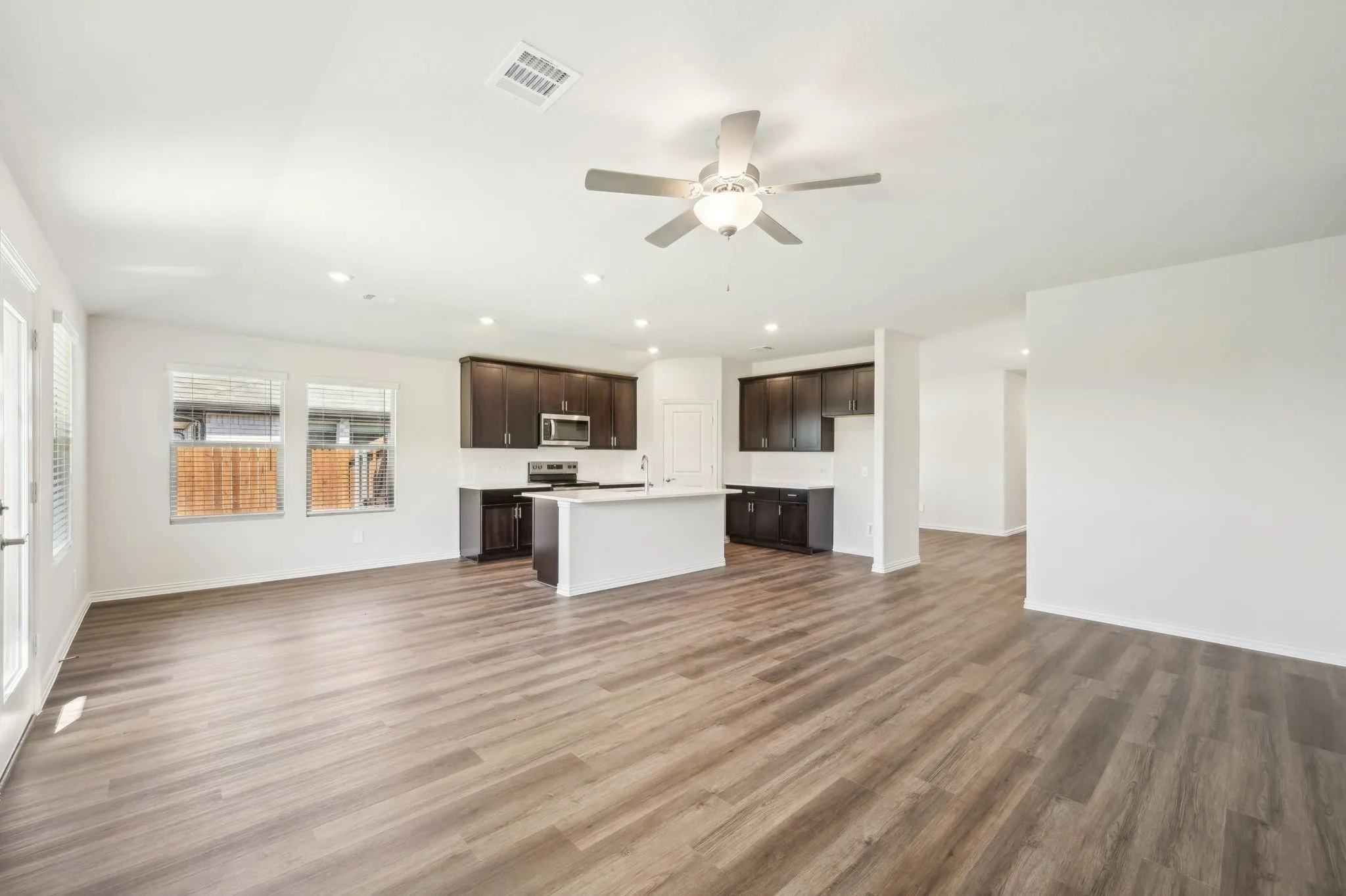 Unfurnished living room with recessed lighting, ceiling fan, visible vents, and light wood-type flooring