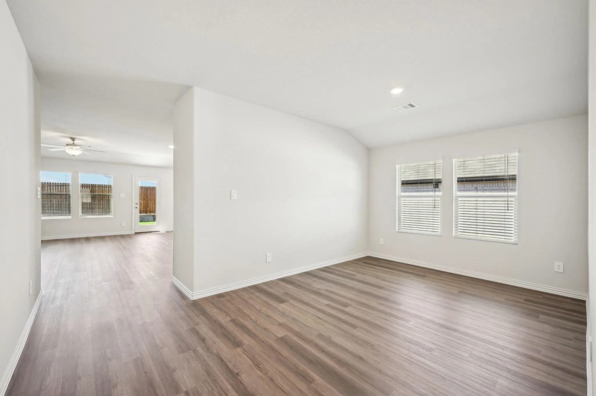 Unfurnished room featuring baseboards, a ceiling fan, wood finished floors, and visible vents