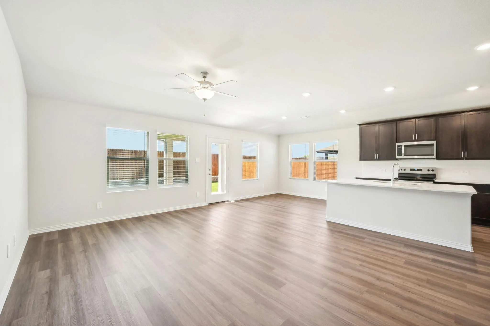 Kitchen with open floor plan, appliances with stainless steel finishes, and wood finished floors