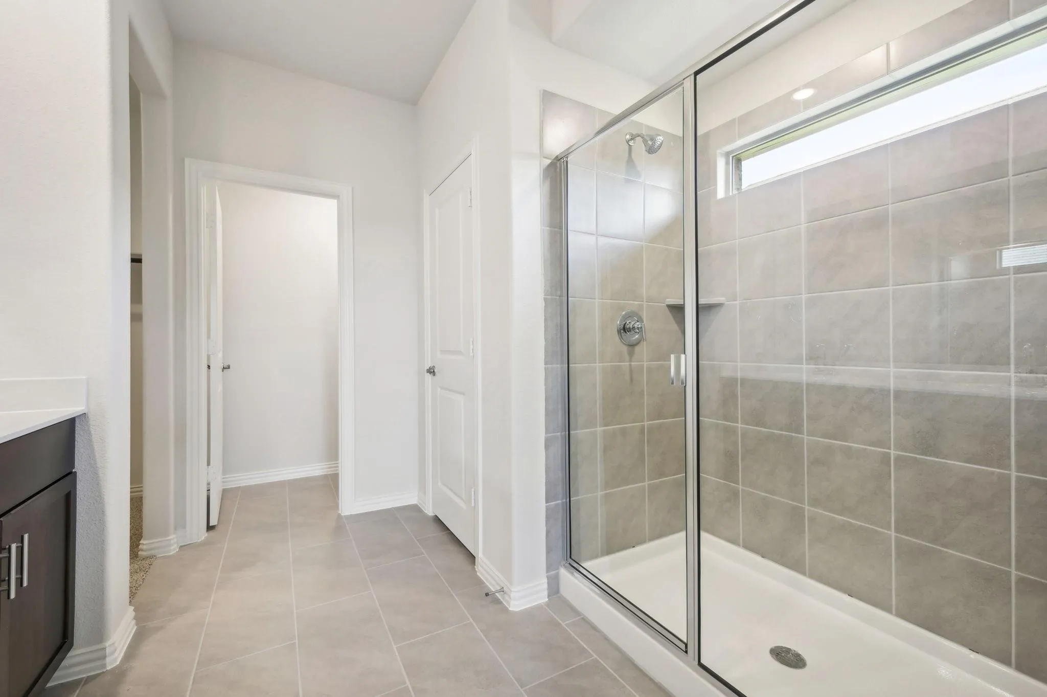 Full bath with vanity, tile patterned floors, baseboards, and a shower stall