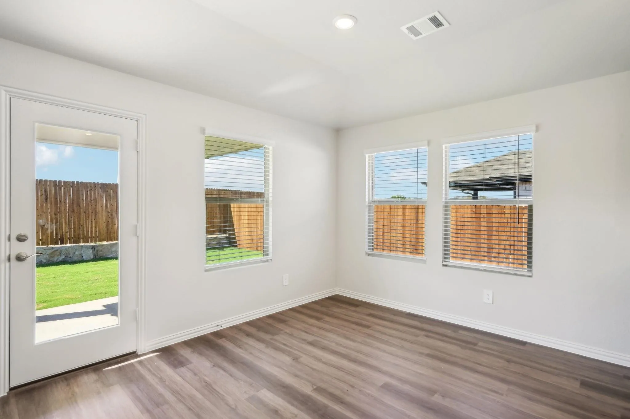 Unfurnished room featuring visible vents, recessed lighting, baseboards, and wood finished floors