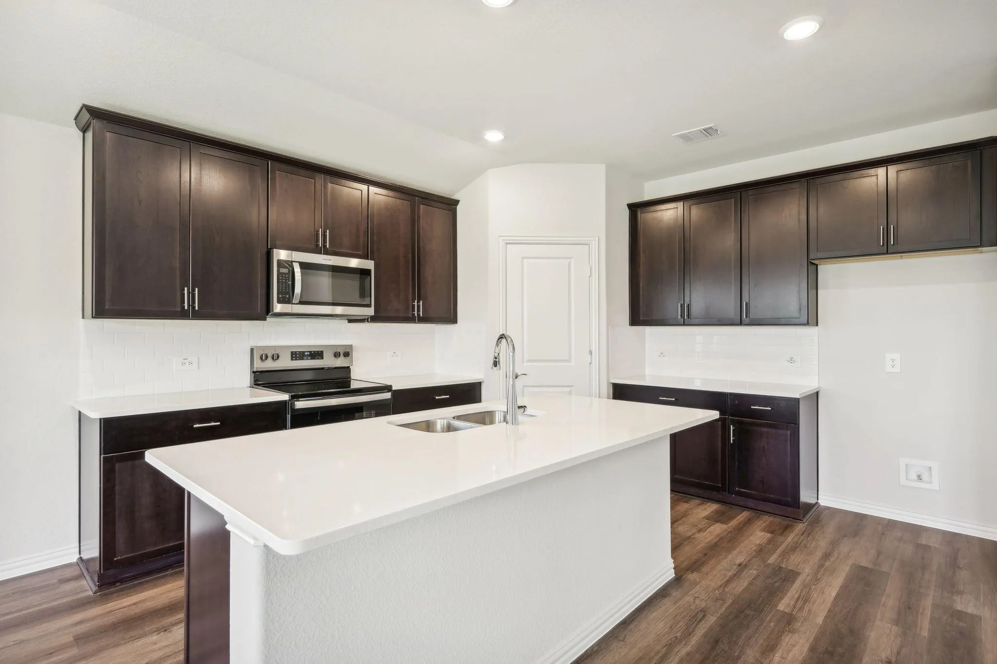 Kitchen featuring baseboards, appliances with stainless steel finishes, visible vents, and dark wood-type flooring