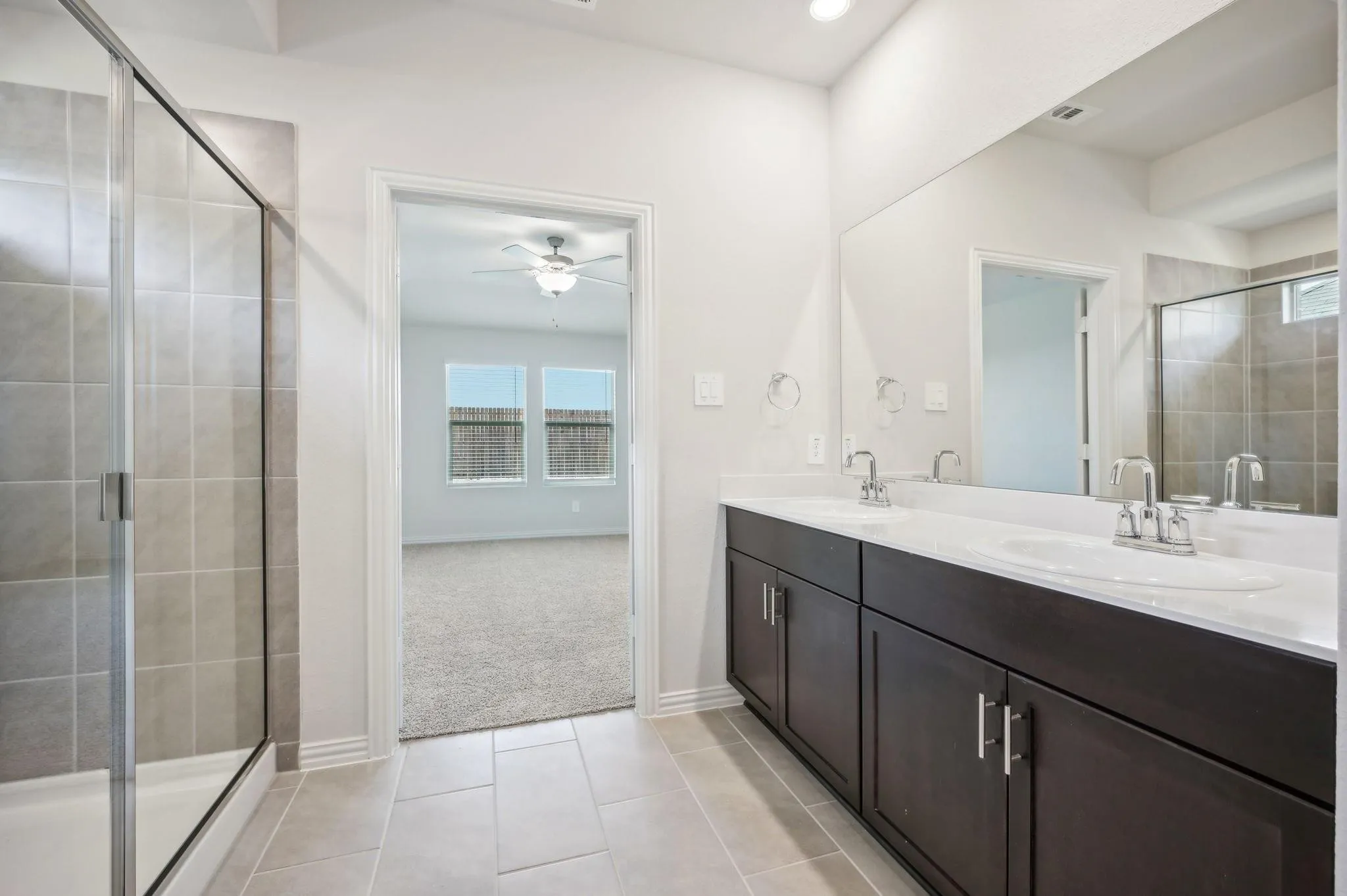 Bathroom with a sink, ceiling fan, tile patterned floors, and a shower stall