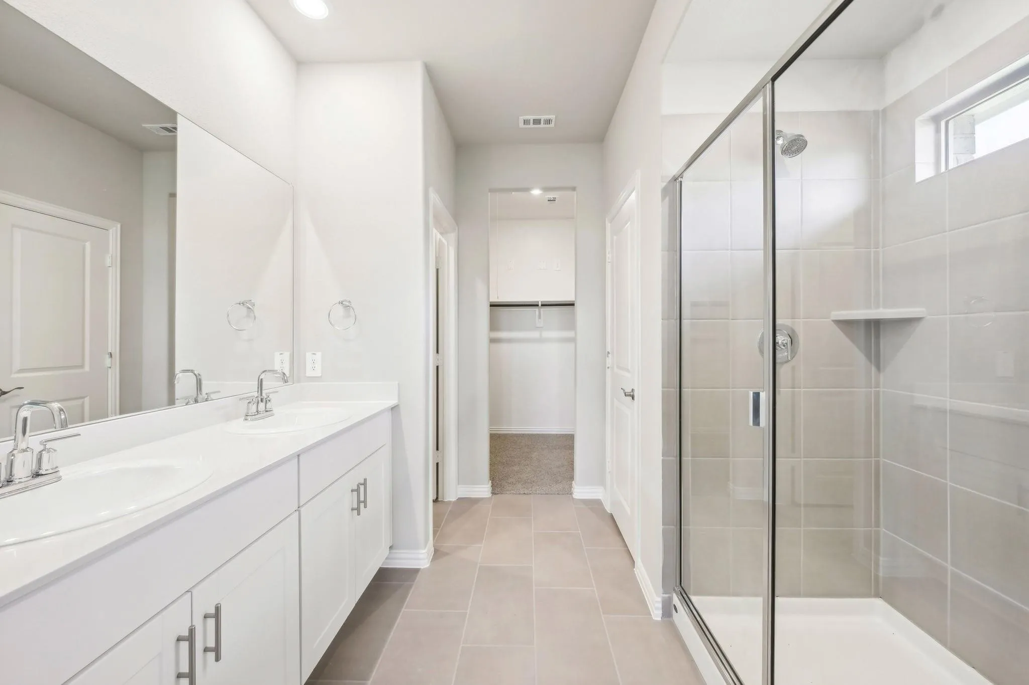 Bathroom featuring baseboards, visible vents, a sink, and a stall shower