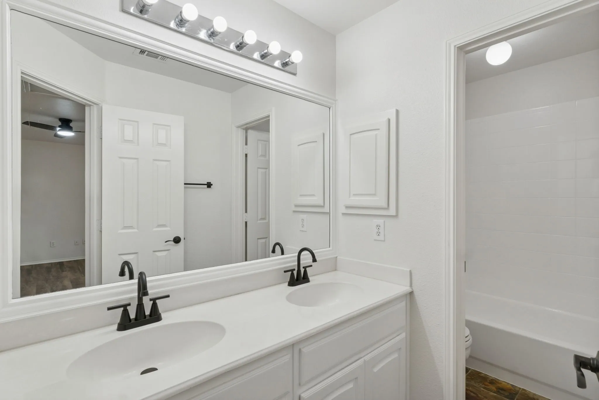 Double vanity with white countertops, undermount sinks, and matte black fixtures
