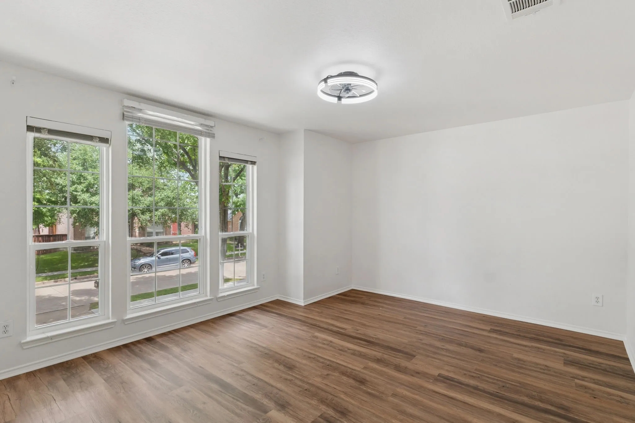 Wood-finish flooring throughout, multiple windows, and a flush mount lighting fixture
