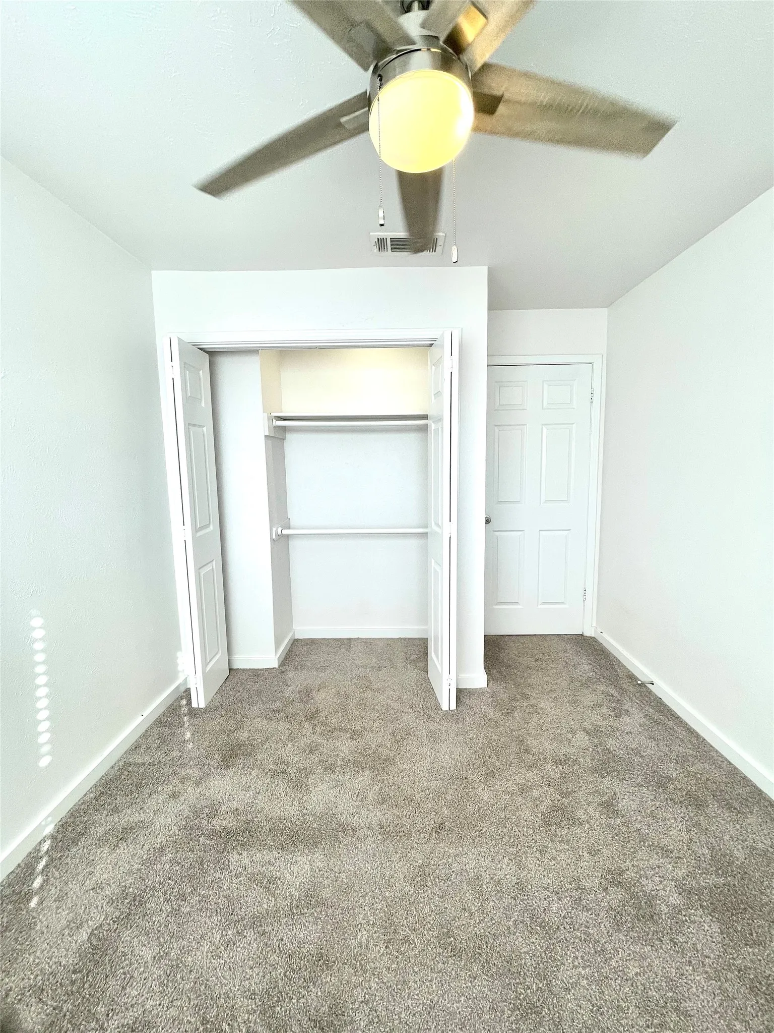 Unfurnished bedroom with carpet flooring, a closet, and ceiling fan