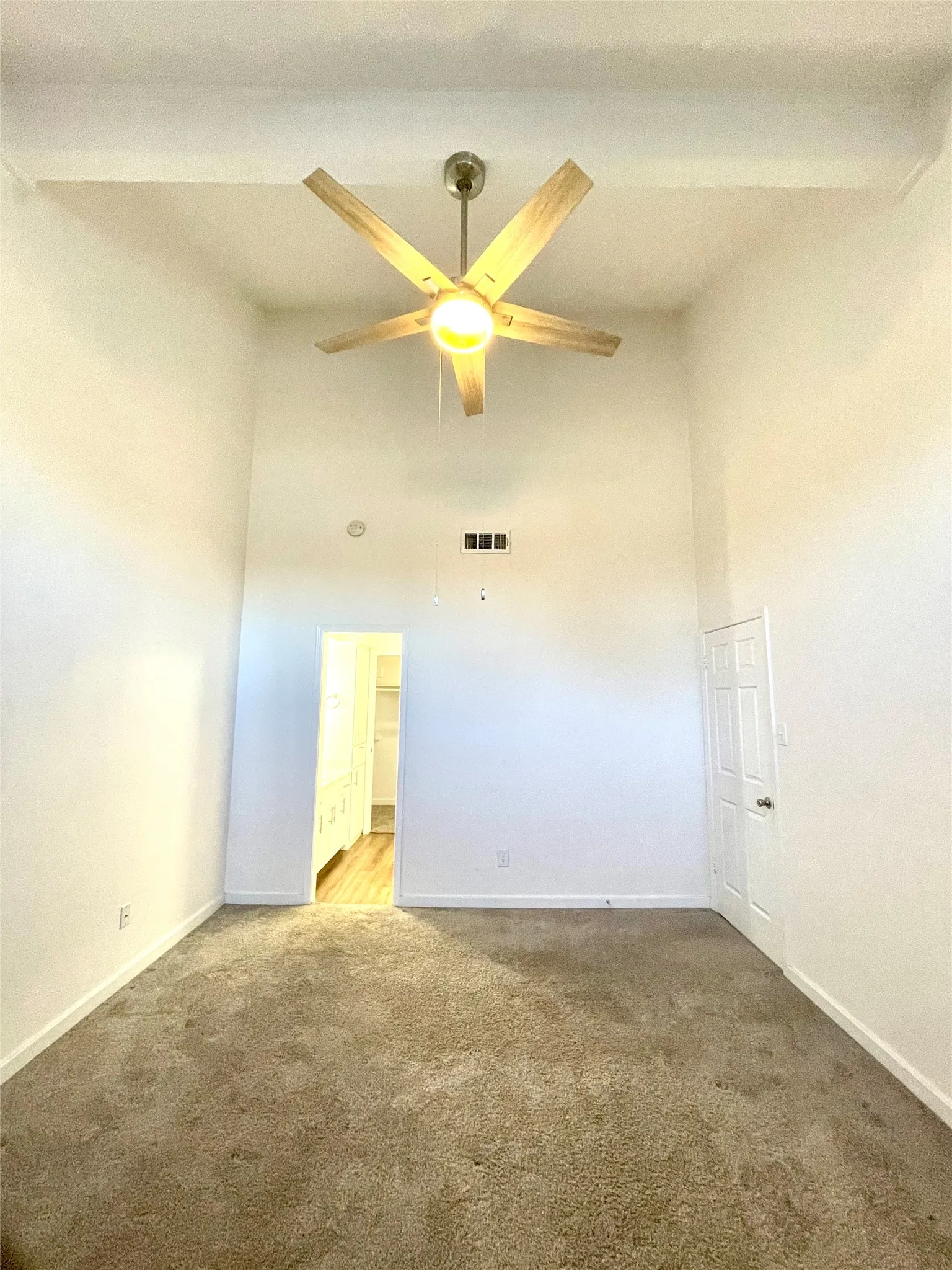Unfurnished room featuring beam ceiling, ceiling fan, and carpet flooring
