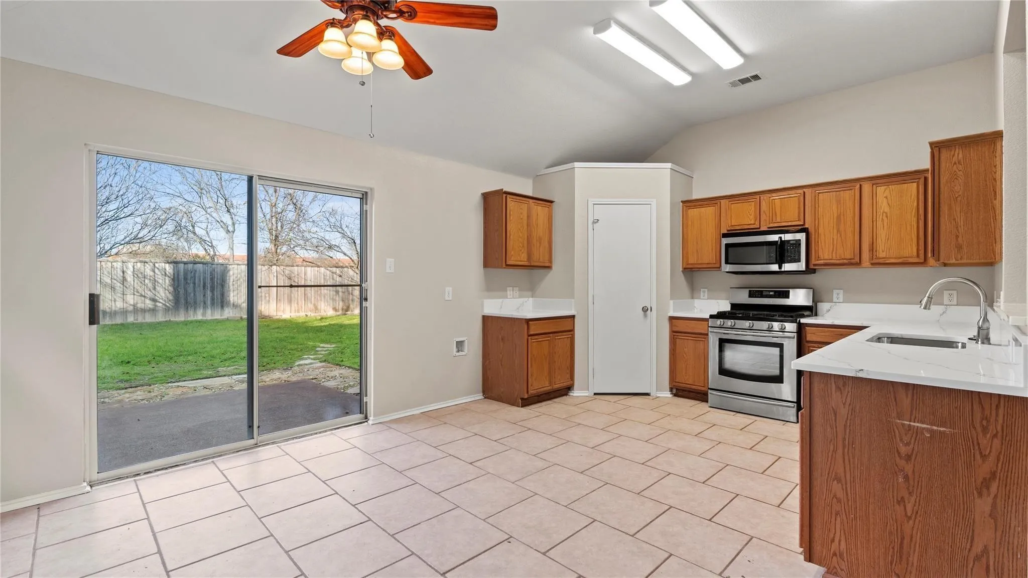 Kitchen featuring wood-finish cabinetry, stainless steel appliances, and light-toned countertops