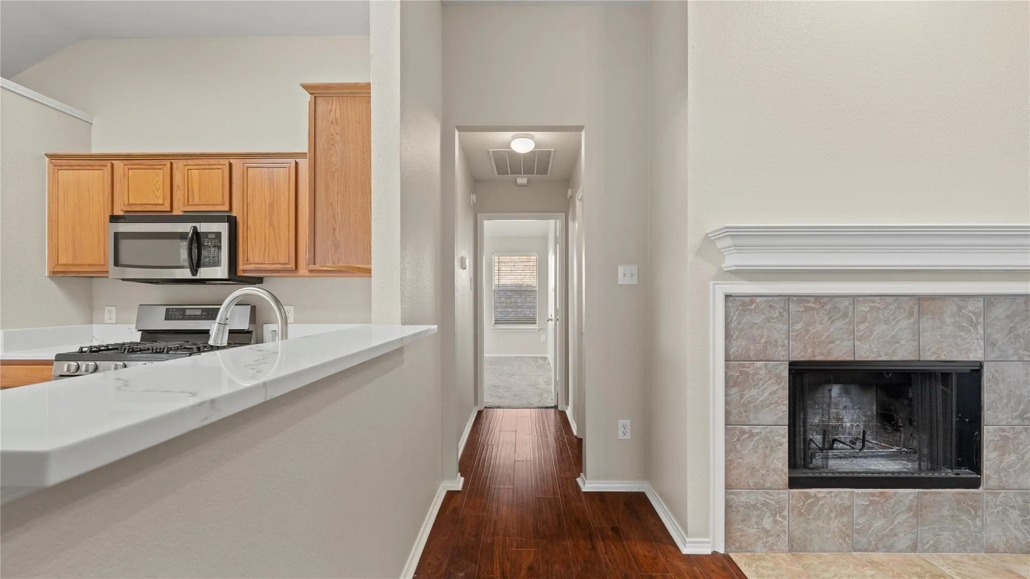 Kitchen featuring wood-finish cabinetry, stainless steel appliances, and a gas range