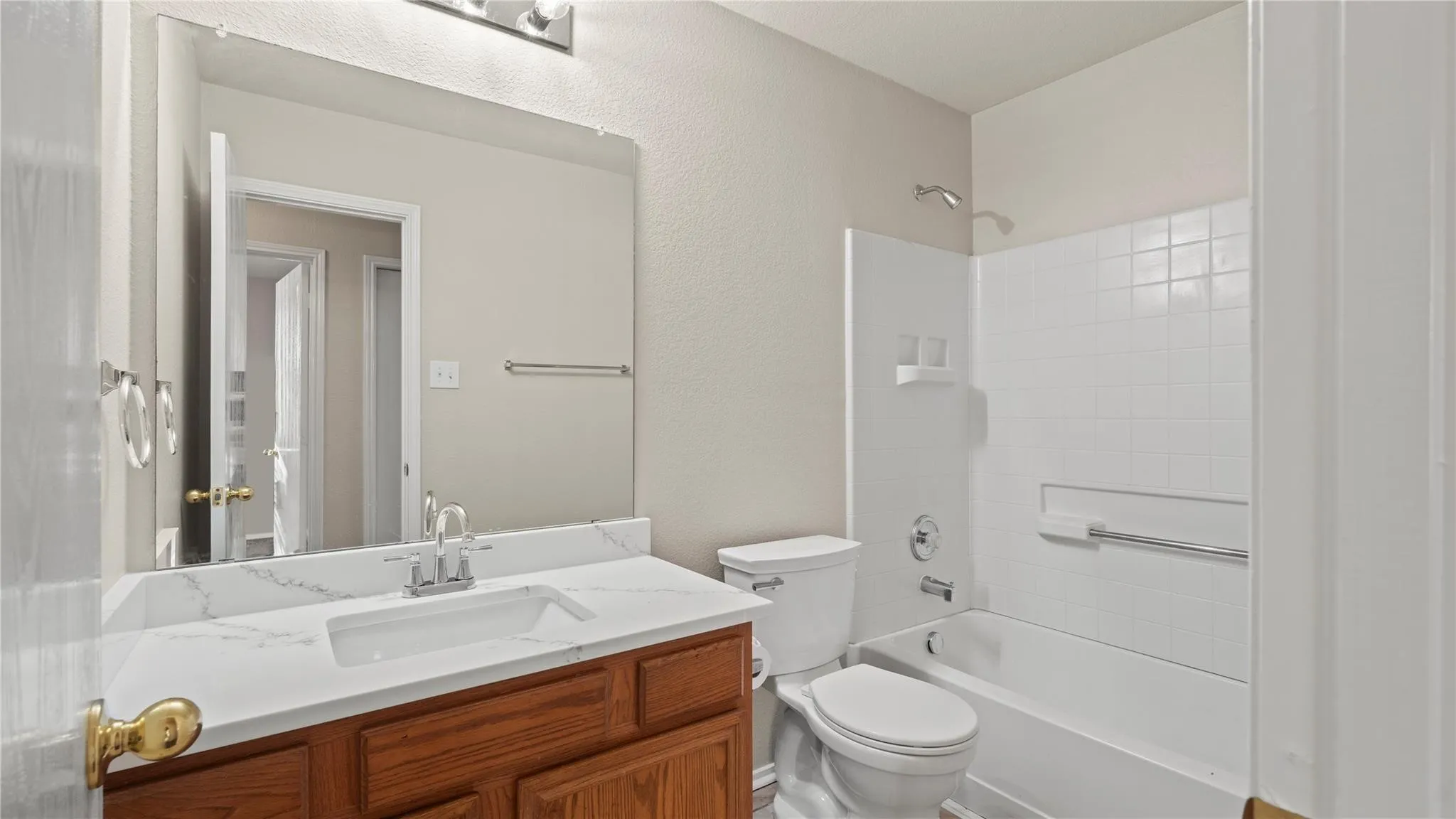 Bathroom featuring a vanity with wood-finish cabinetry, a white countertop, and a built-in sink