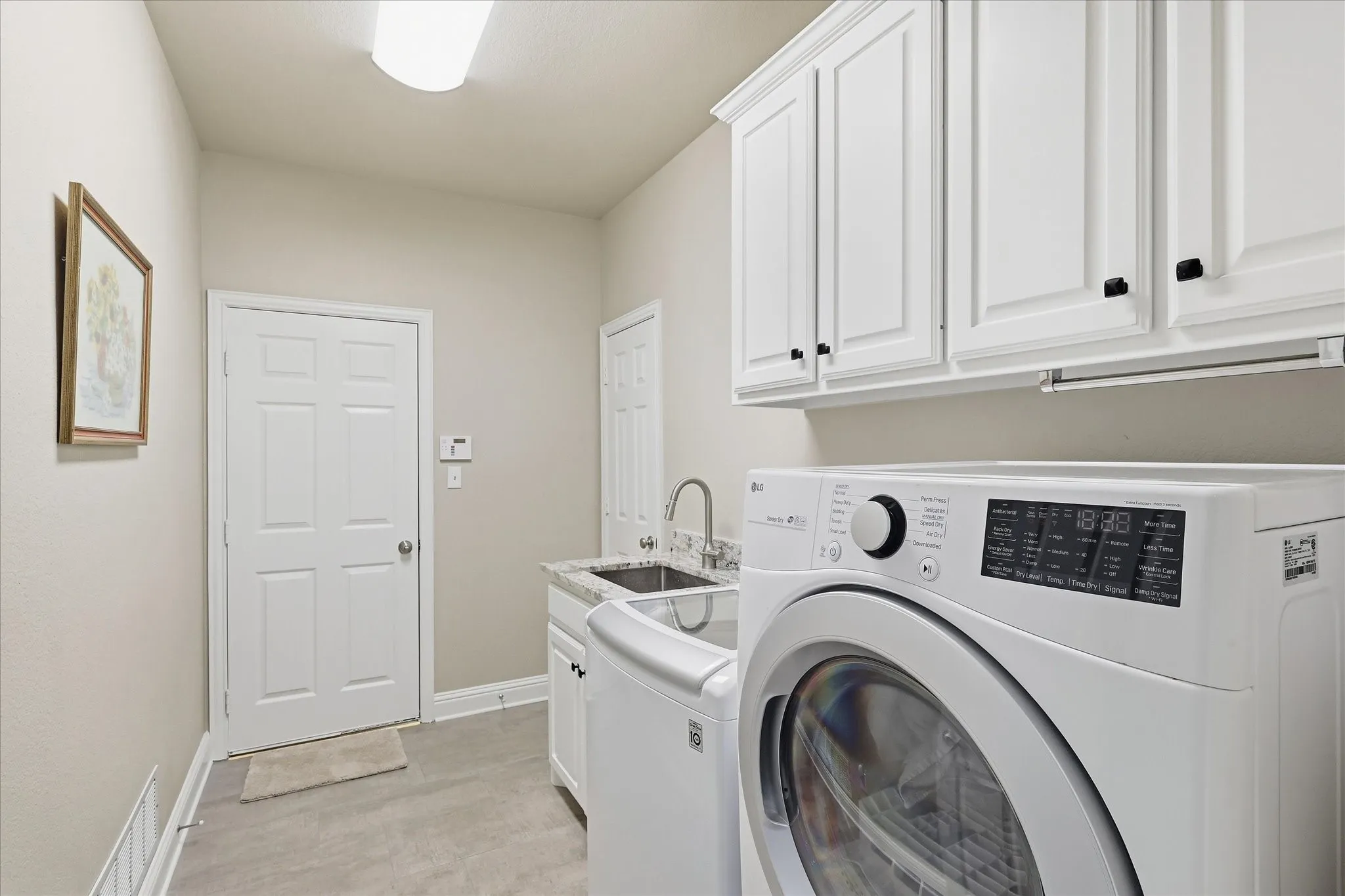 Spacious utility room with a sink & built-in cabinets.