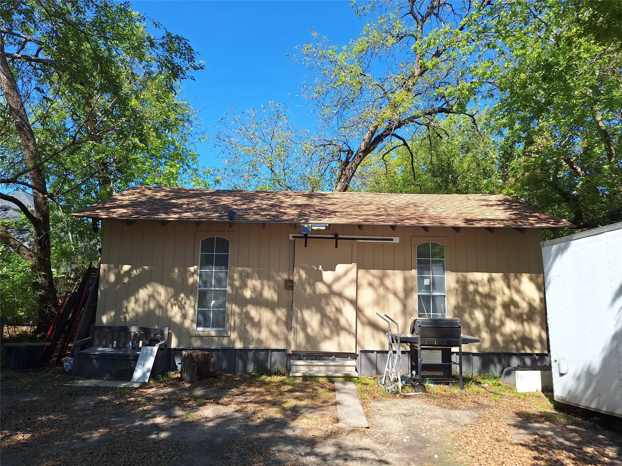 Utility building with arched windows and a shingle roof