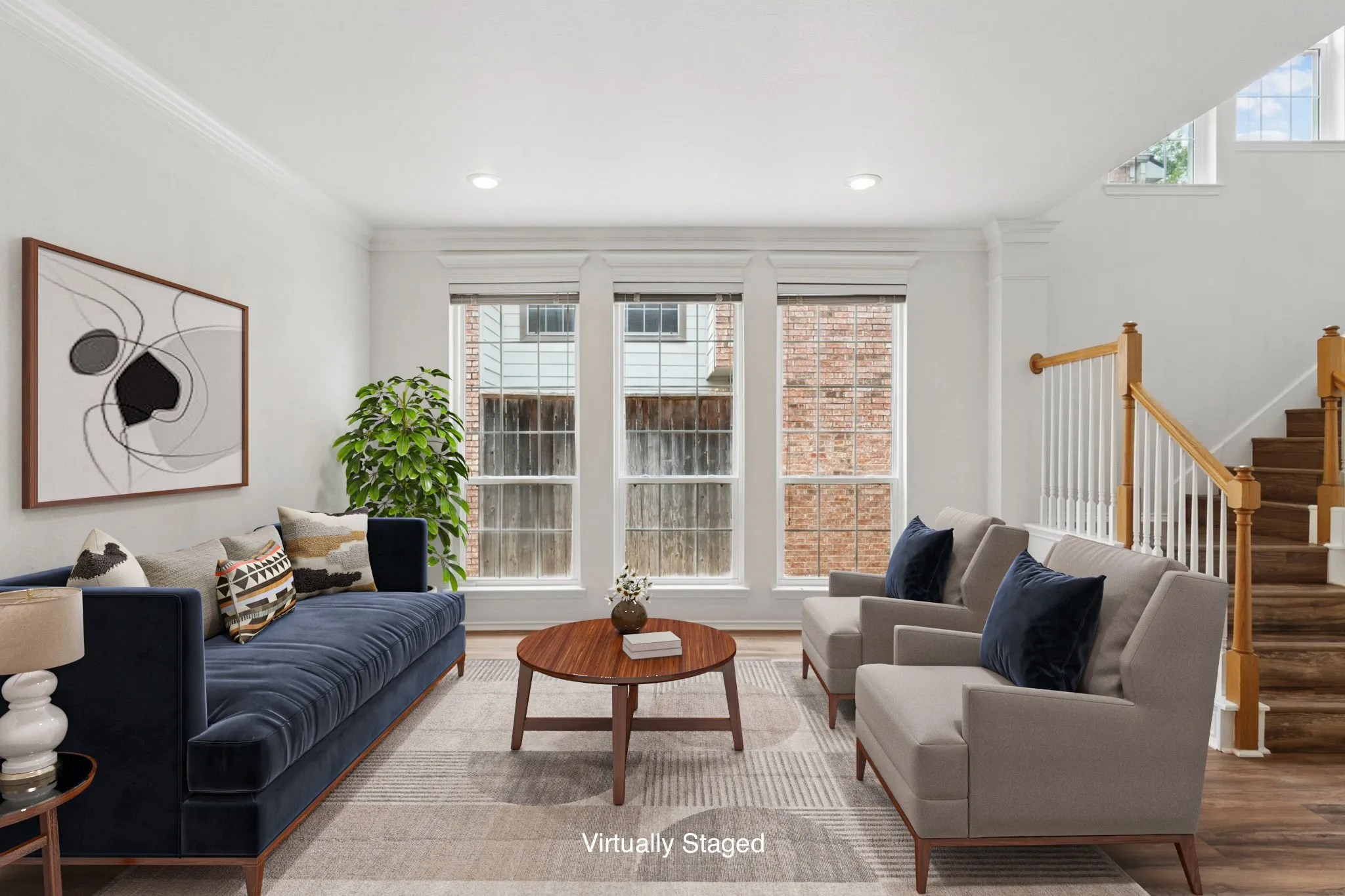 Recessed lighting illuminating crown molding, wood-finish flooring, and a prominent staircase with a wood handrail