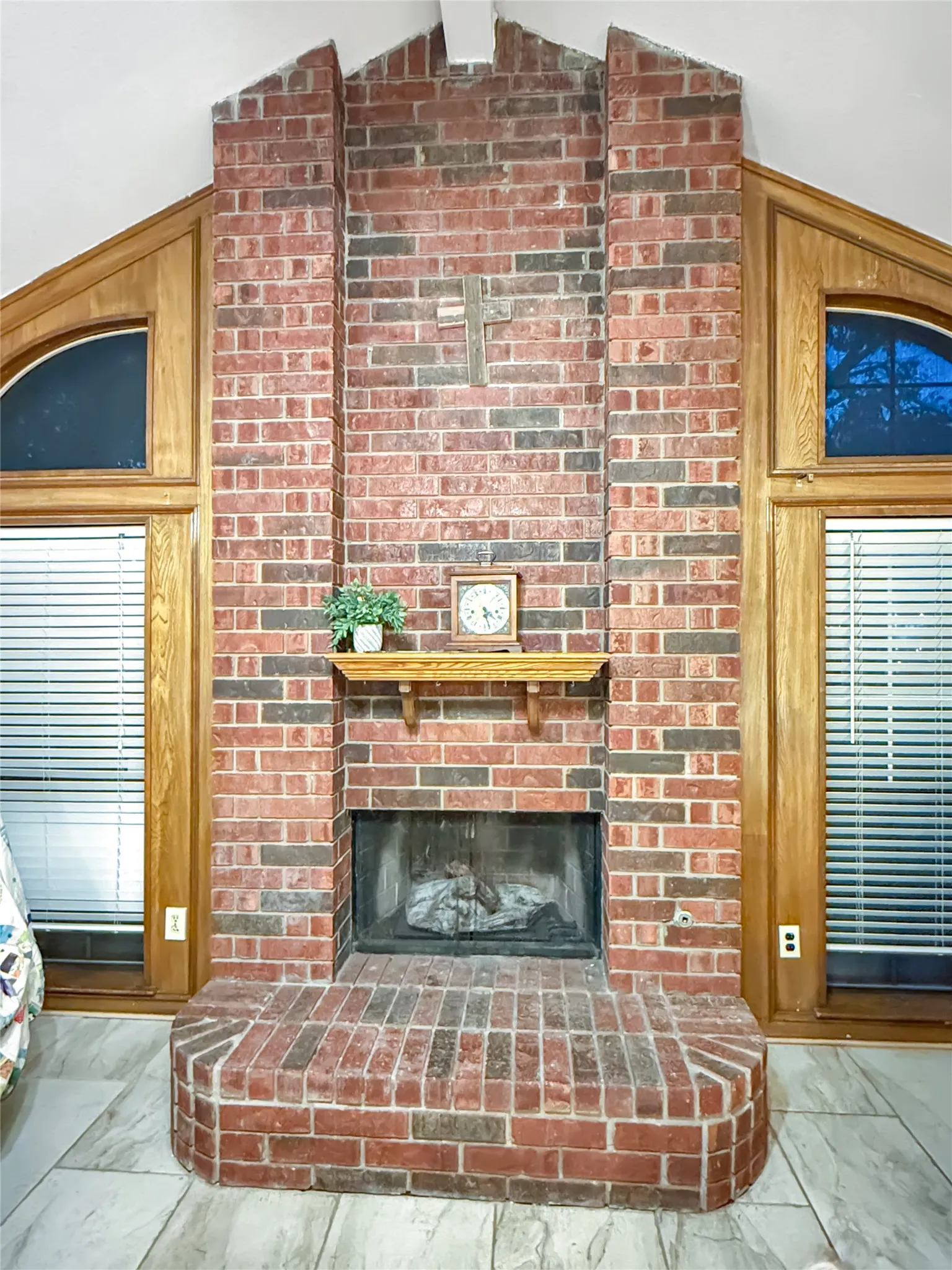 Brick fireplace with a wood mantel, raised hearth, and integrated firebox