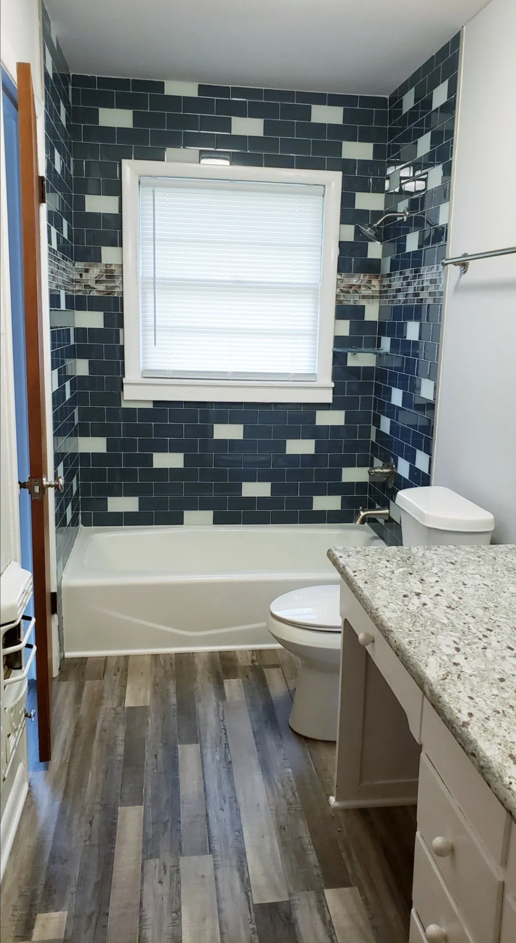 Full bathroom with tiled shower / bath, vanity, toilet, and wood-type flooring
