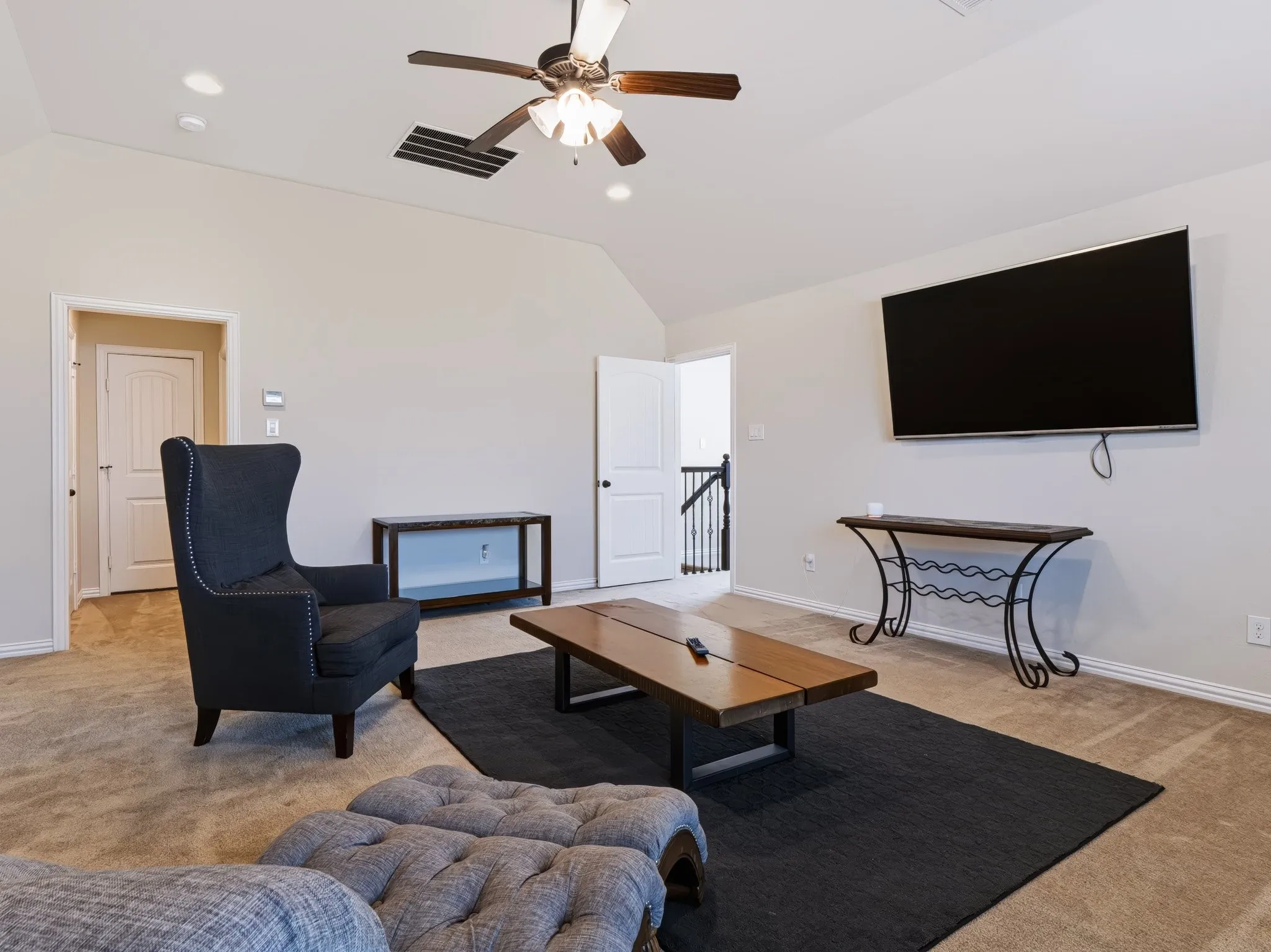 Vaulted ceiling with recessed lighting and a ceiling fan