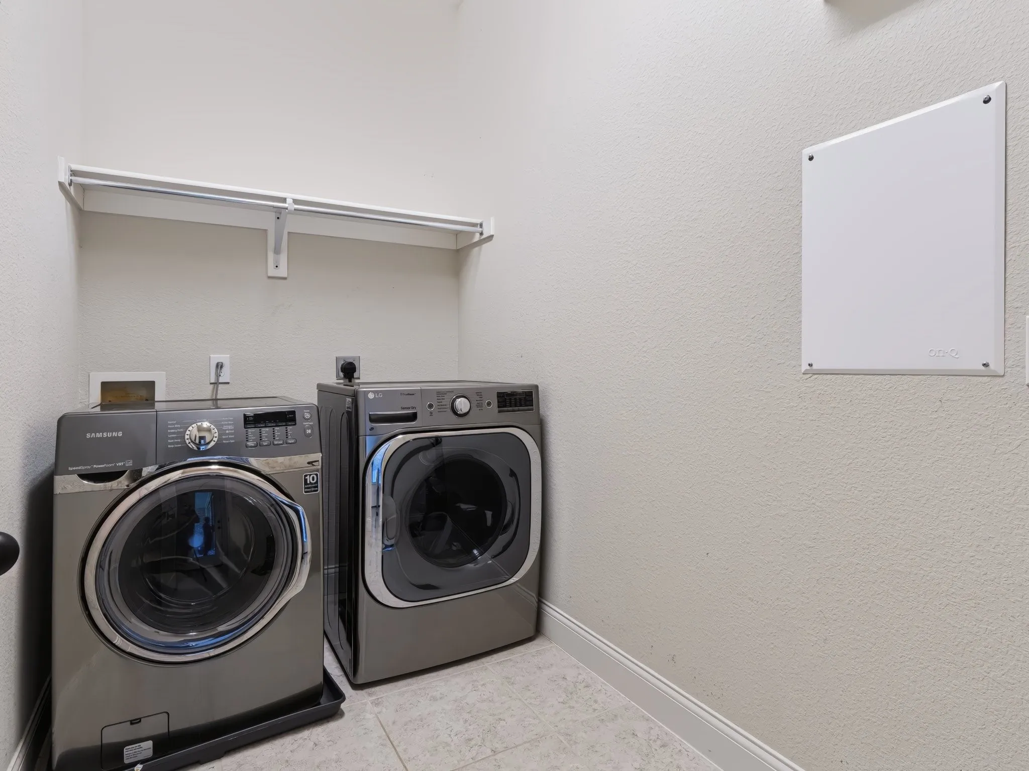 Laundry area featuring a tiled floor and an integrated wall shelf